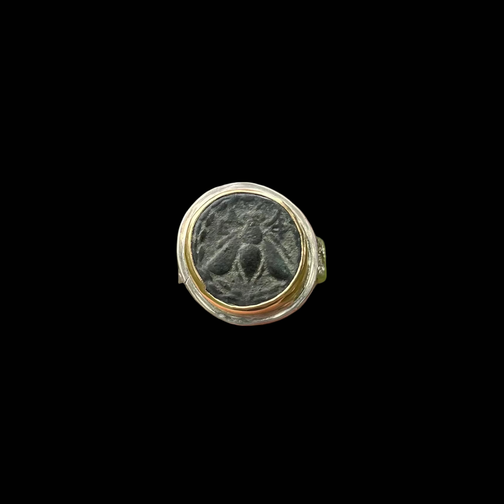 Image of a bee set in gold and silver ring on black background