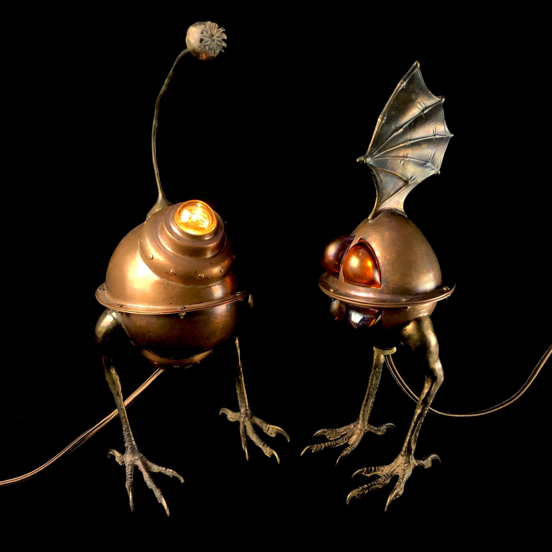 Illuminated desk lamps that look like creatures standing side by side on a black background