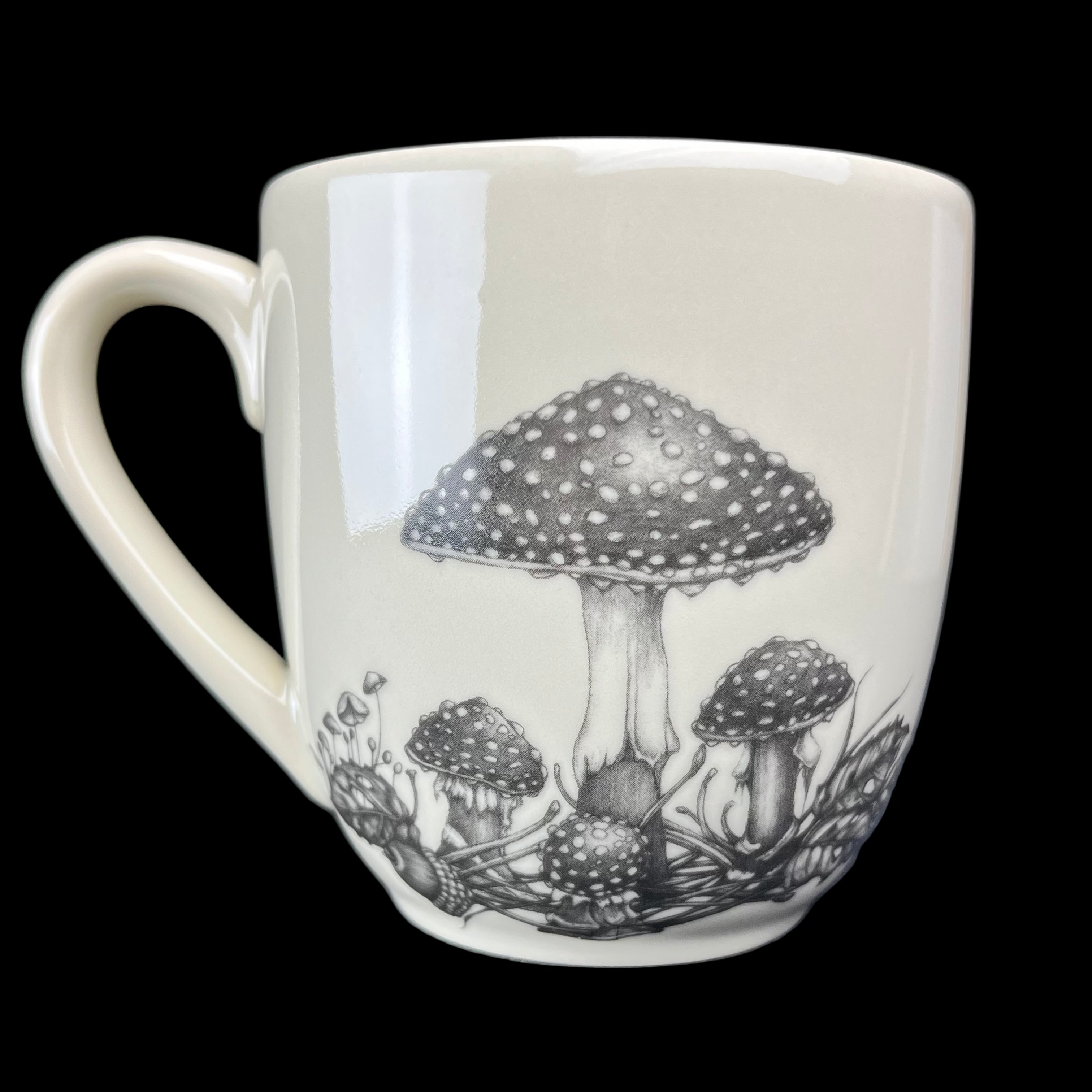 White mug with black mushroom design on a dark background