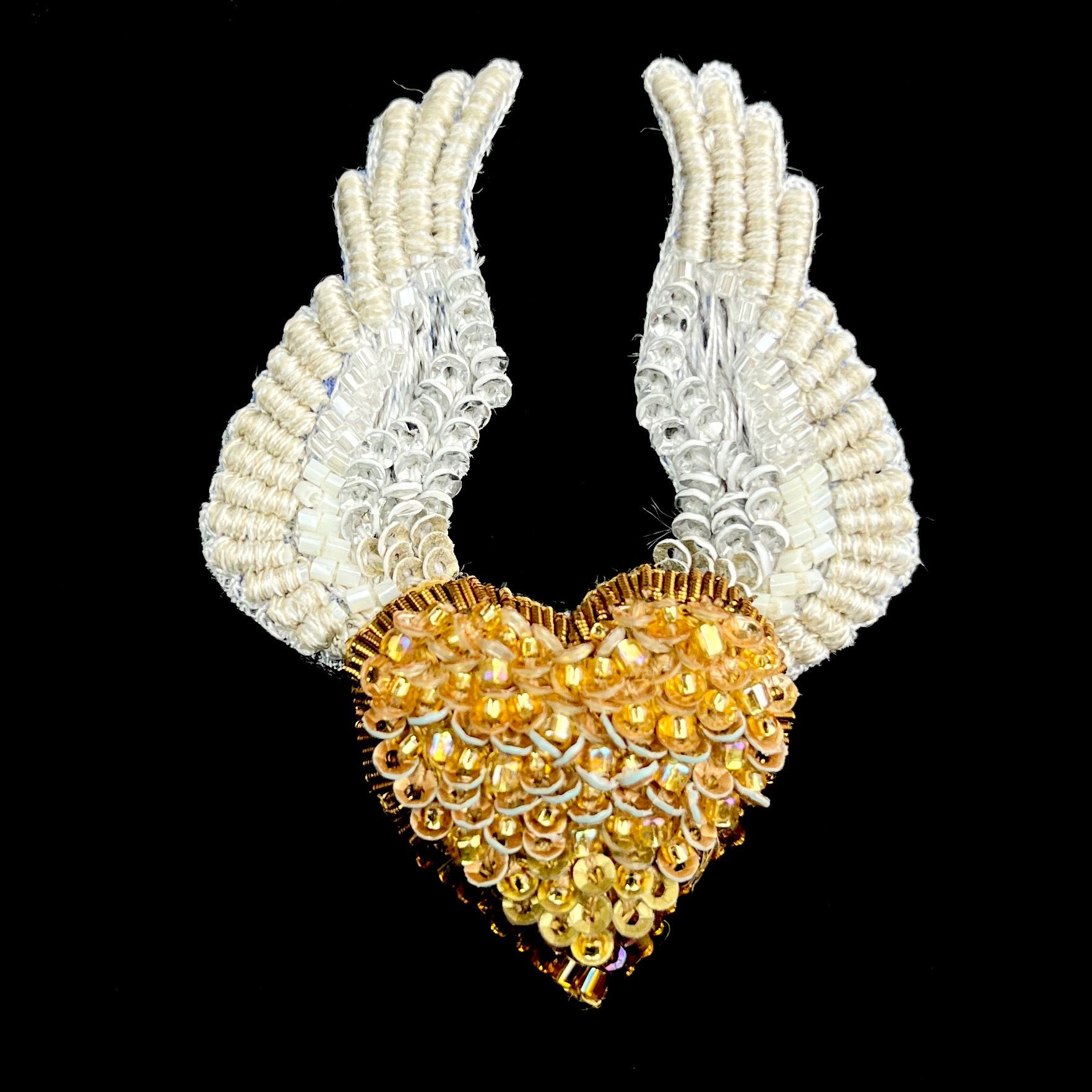 Gold beaded heart with white outstretched wings
