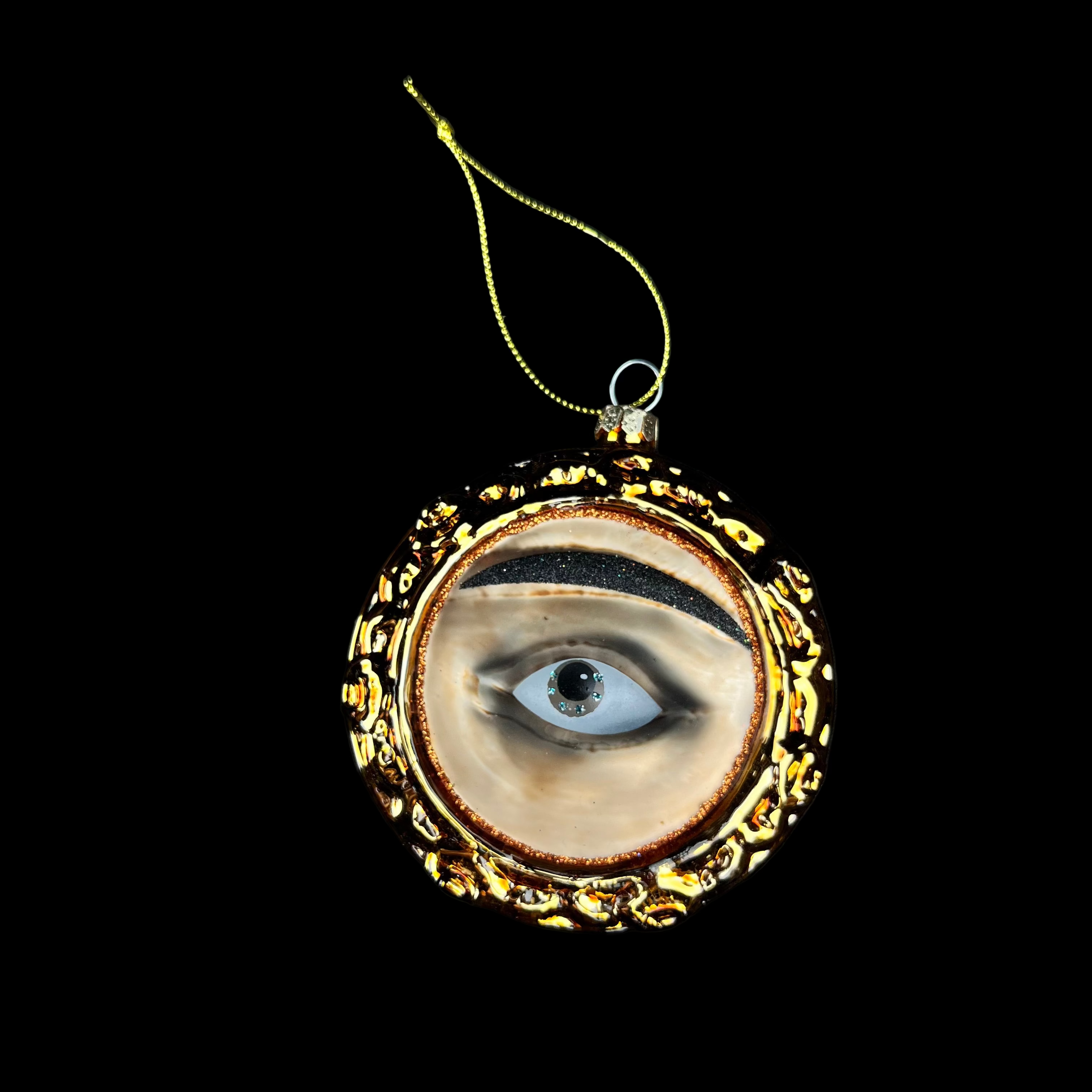 Decorative eye ornament with gold frame on a black background