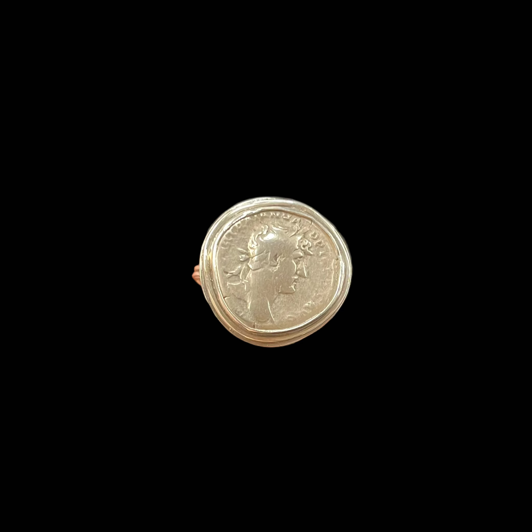 Hand holding a silver coin against a dark surface