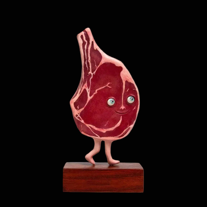 Three dimensional steak sculpture with legs on wooden block 