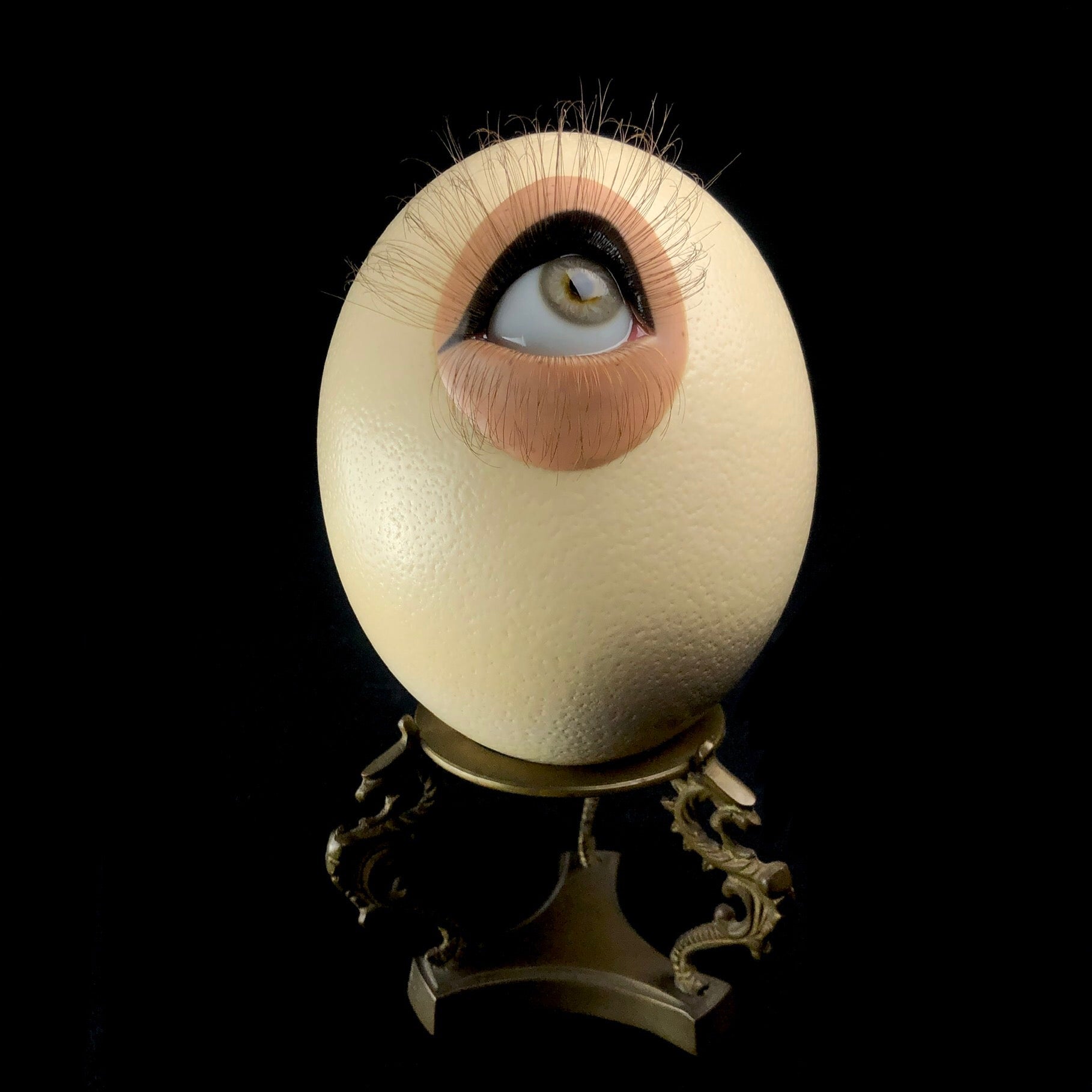Front view of Olly the Ostrich Egg shown on vintage brass stnd