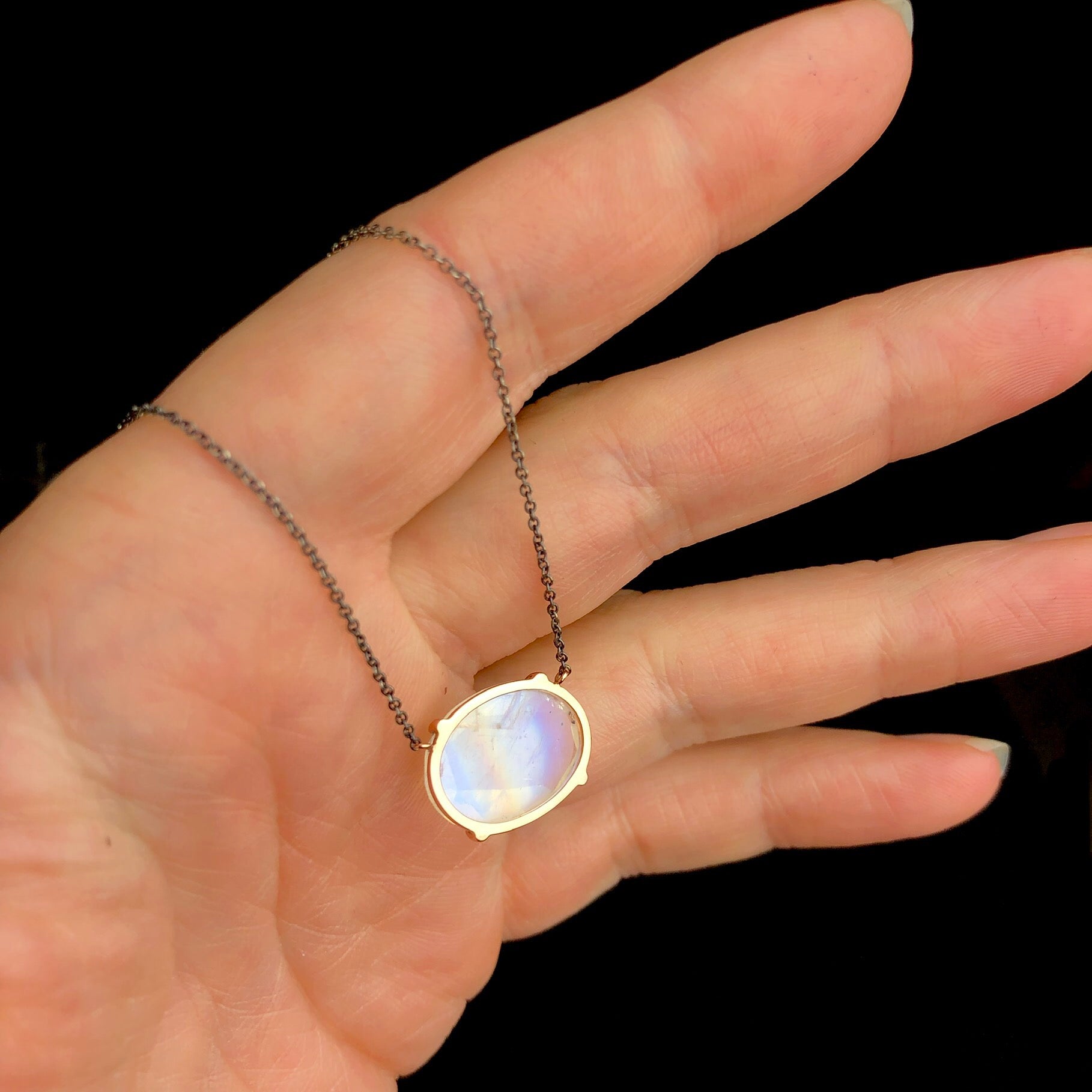 Back view of Rainbow Moonstone with flat cut stone and gold setting
