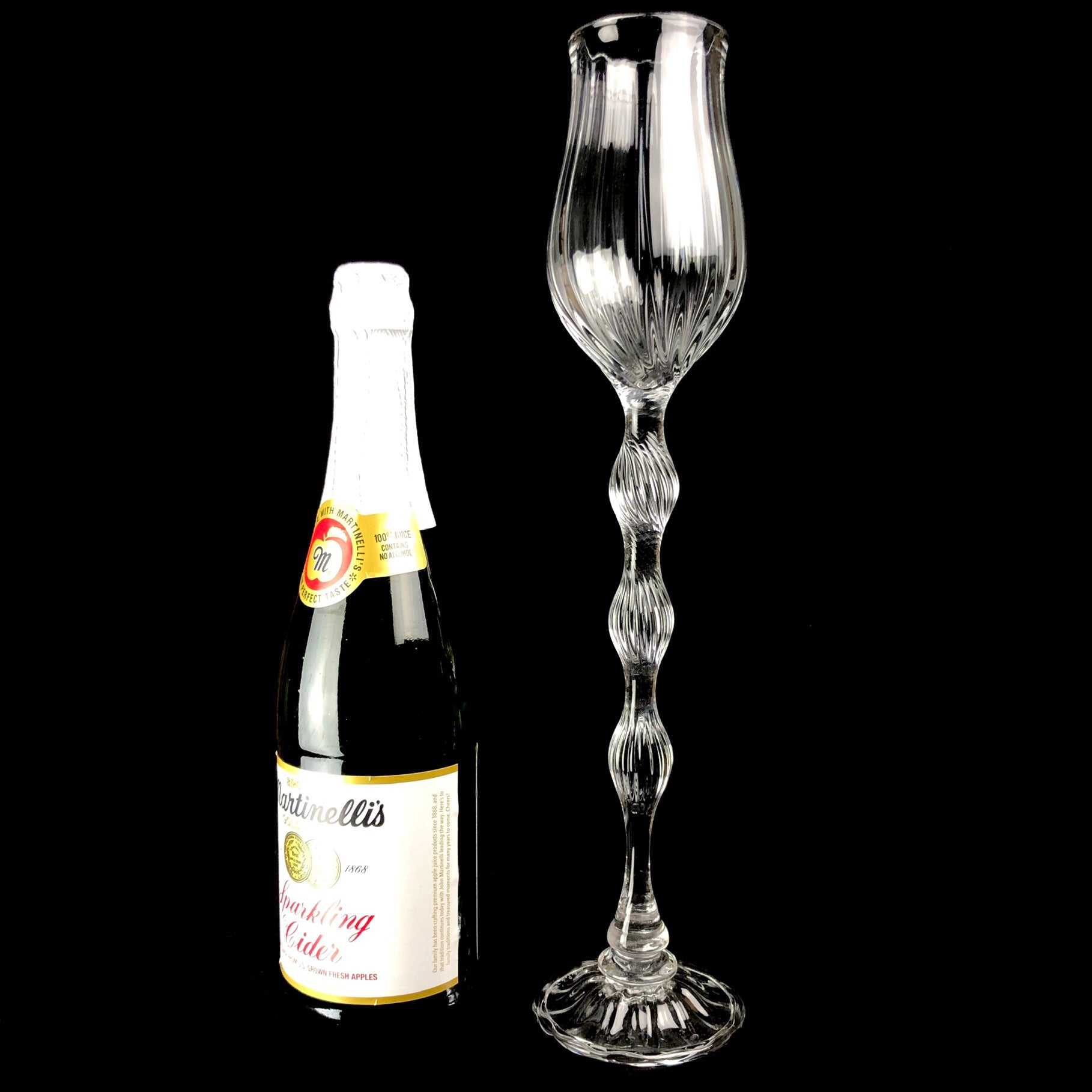 Oversized Glass Goblet shown sitting beside a standard champagne bottle