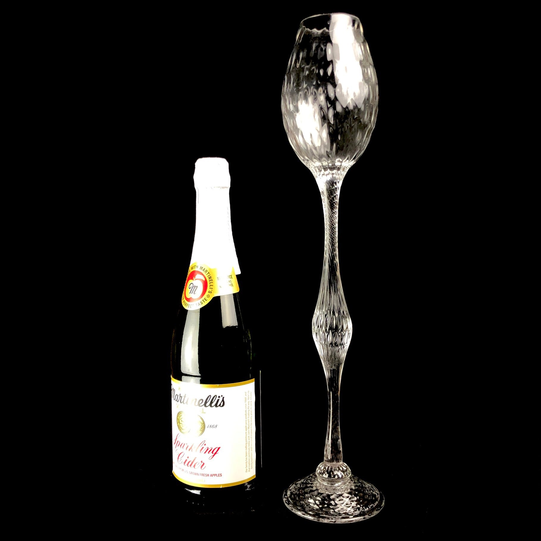 Oversized Glass Goblet shown sitting beside a standard champagne bottle