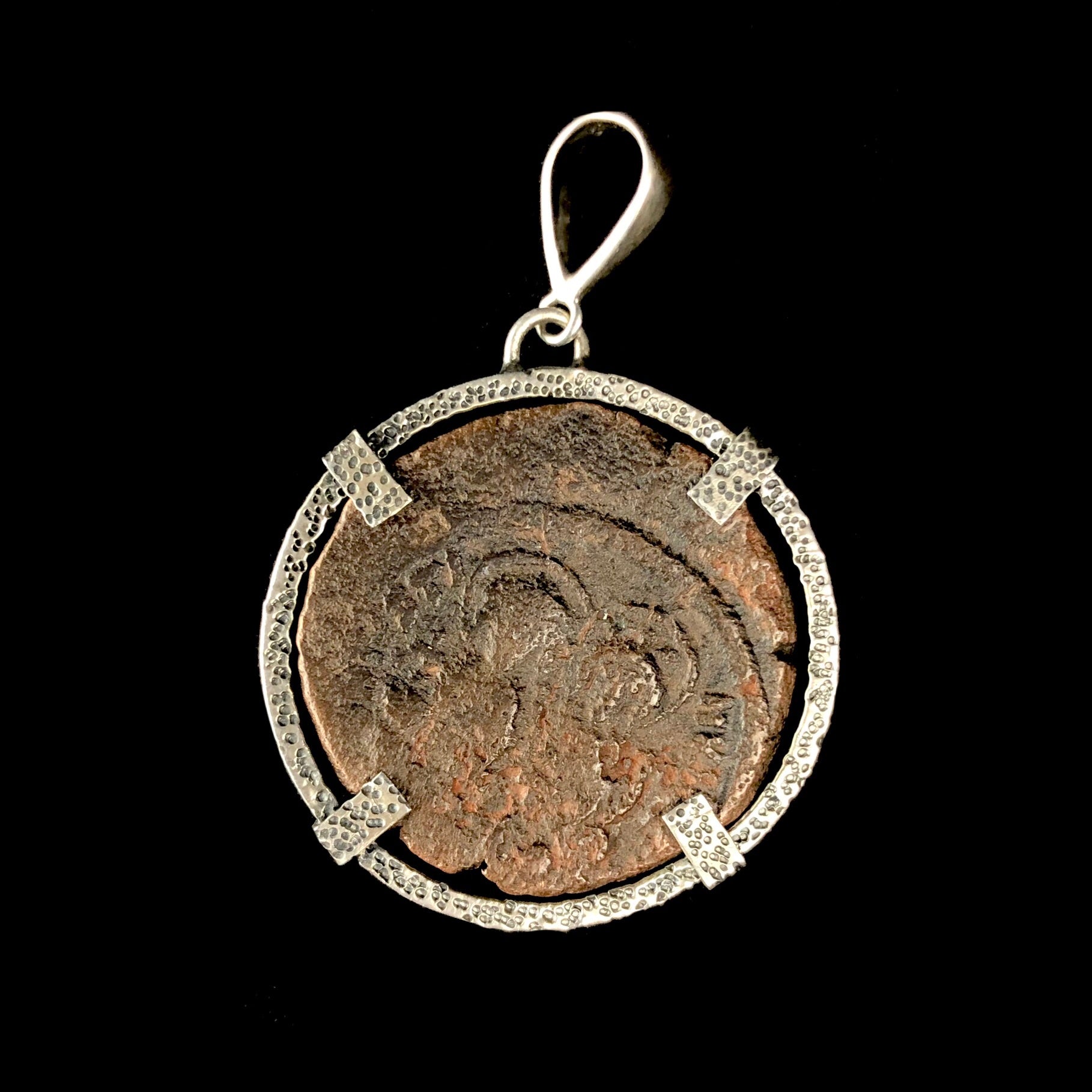 Bronze coin with the faint outline of two figures