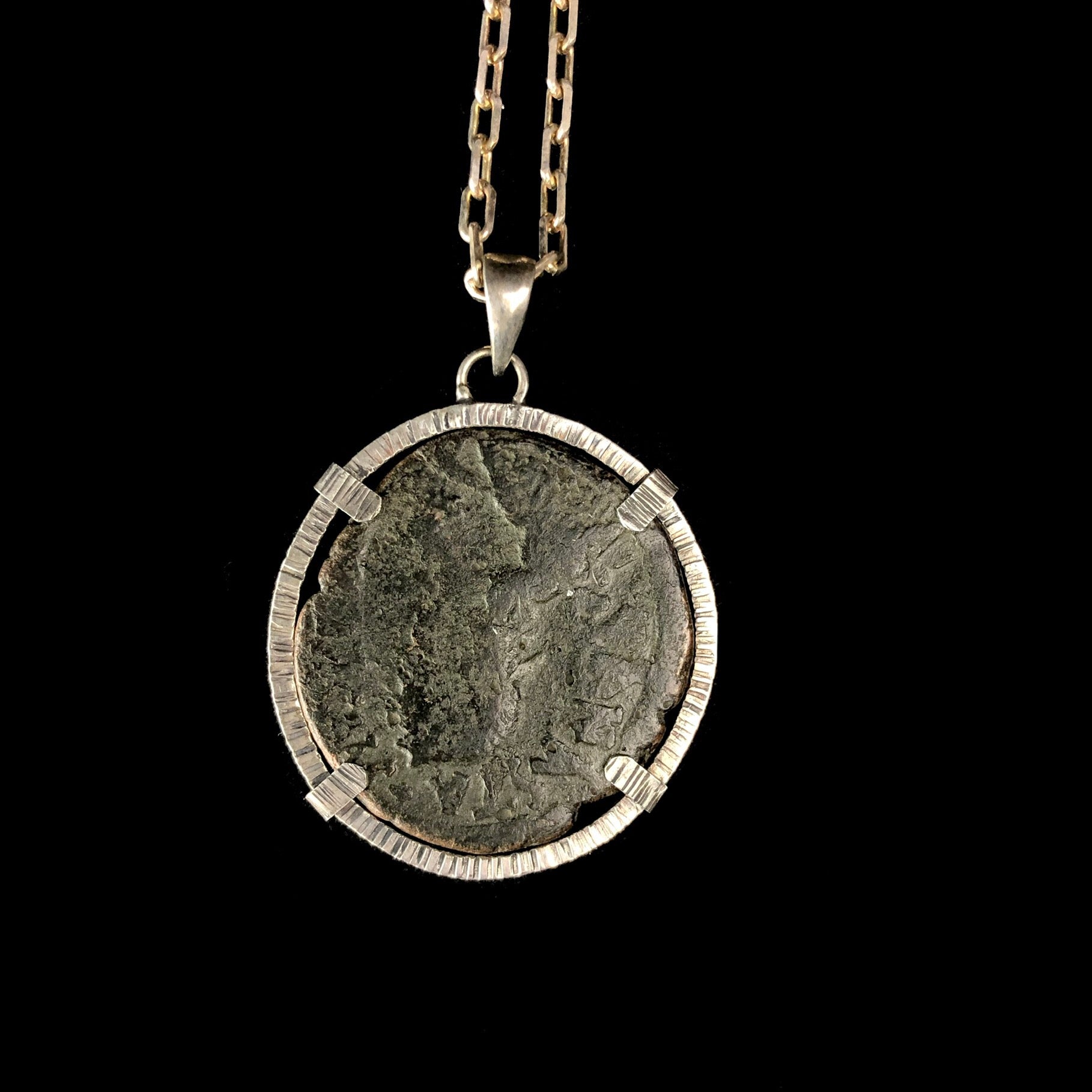 Bronze coin with the faint outline of figure set in silver