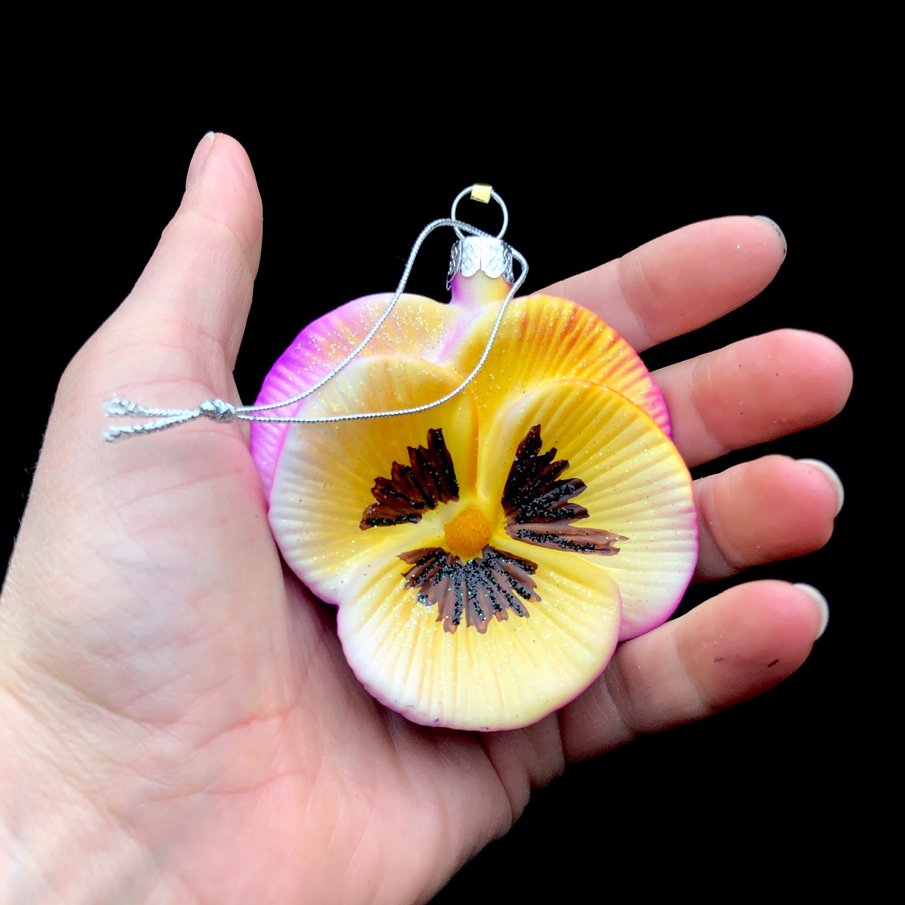 Yellow/Pink Pansy shown in hand