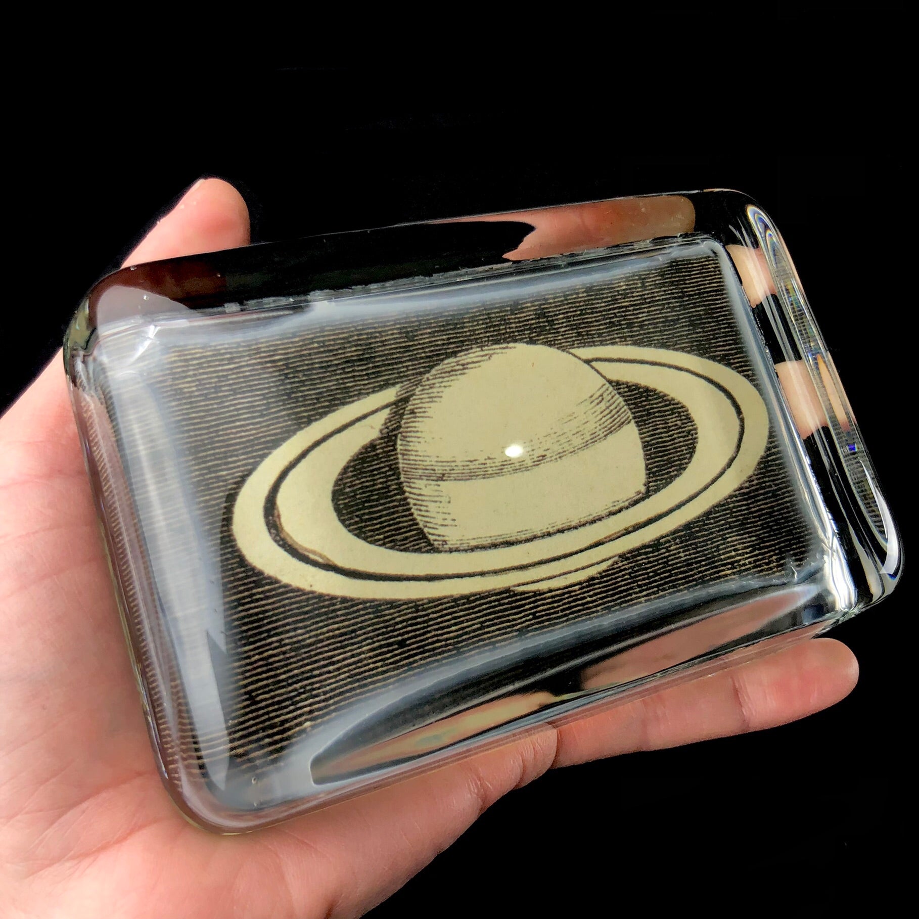 Side view of Rectangular Saturn Paperweight shown in hand