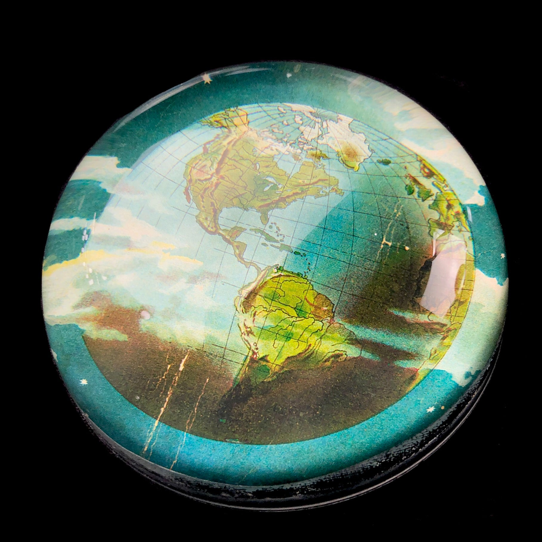 Round convex glass over image of earth