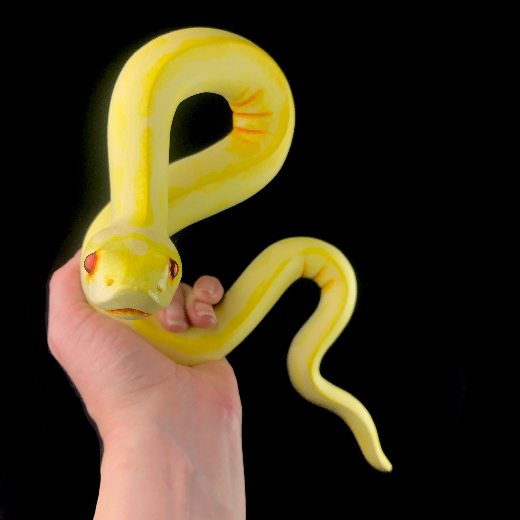Yellow Wall Hanging Snake Sculpture in hand for size reference