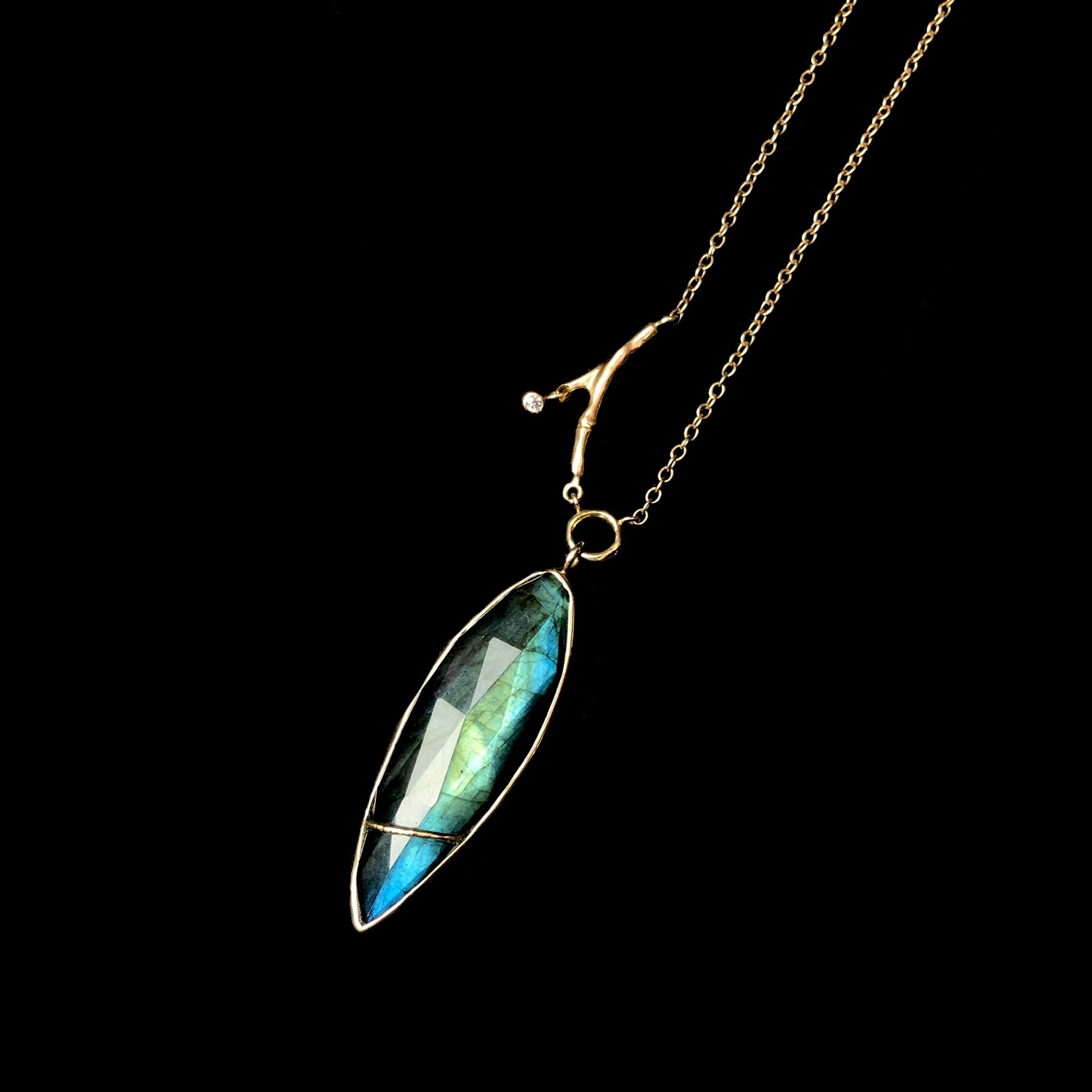 Close up view of faceted labradorite stone and branch accent