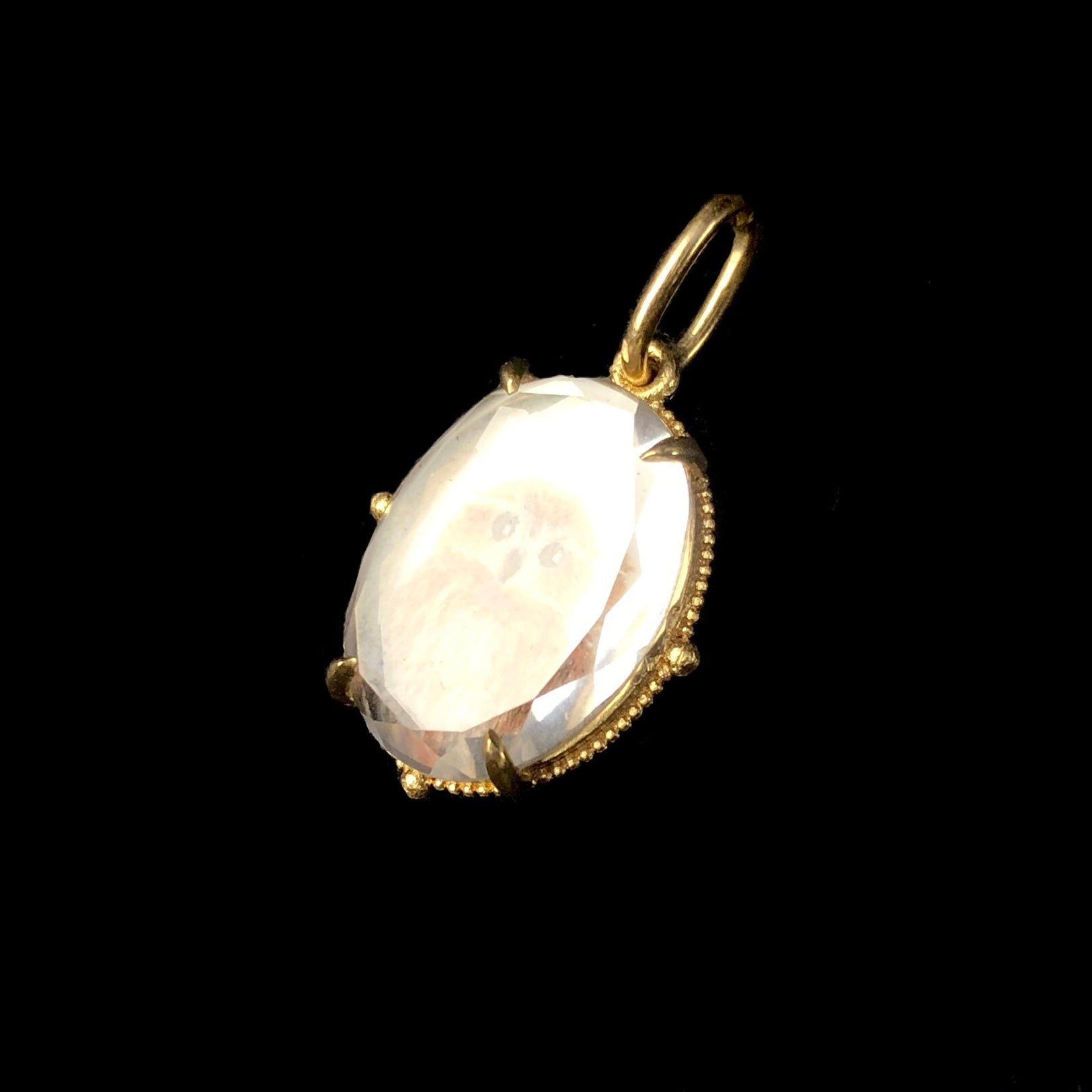 Detail view of White Sapphire Crystal face with gold prong setting