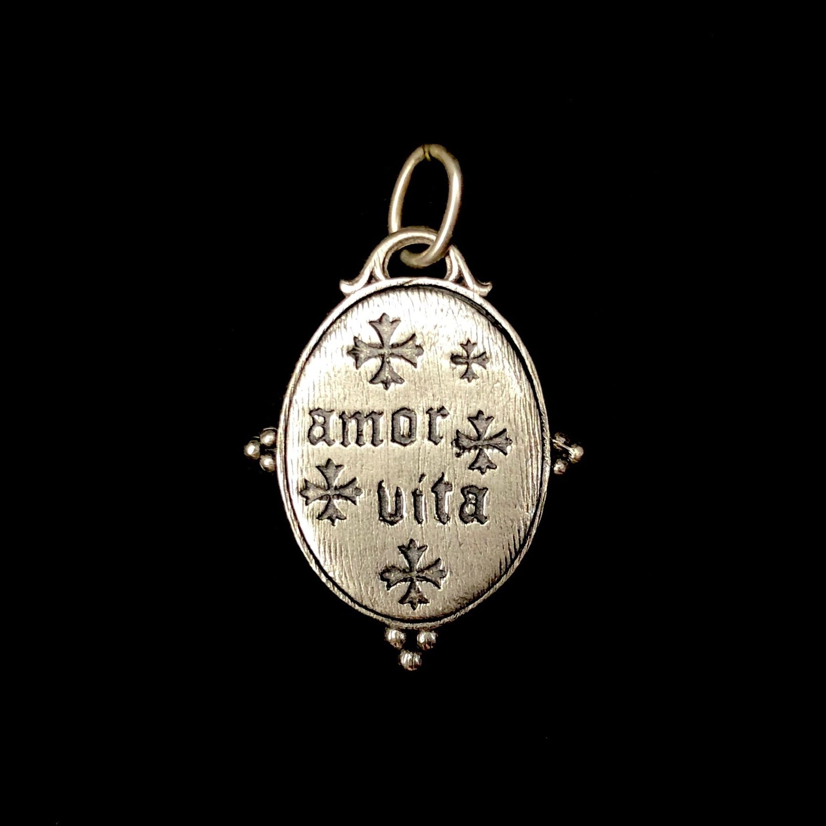 Back view of silver Sacred Heart Charm with words "amor vita"