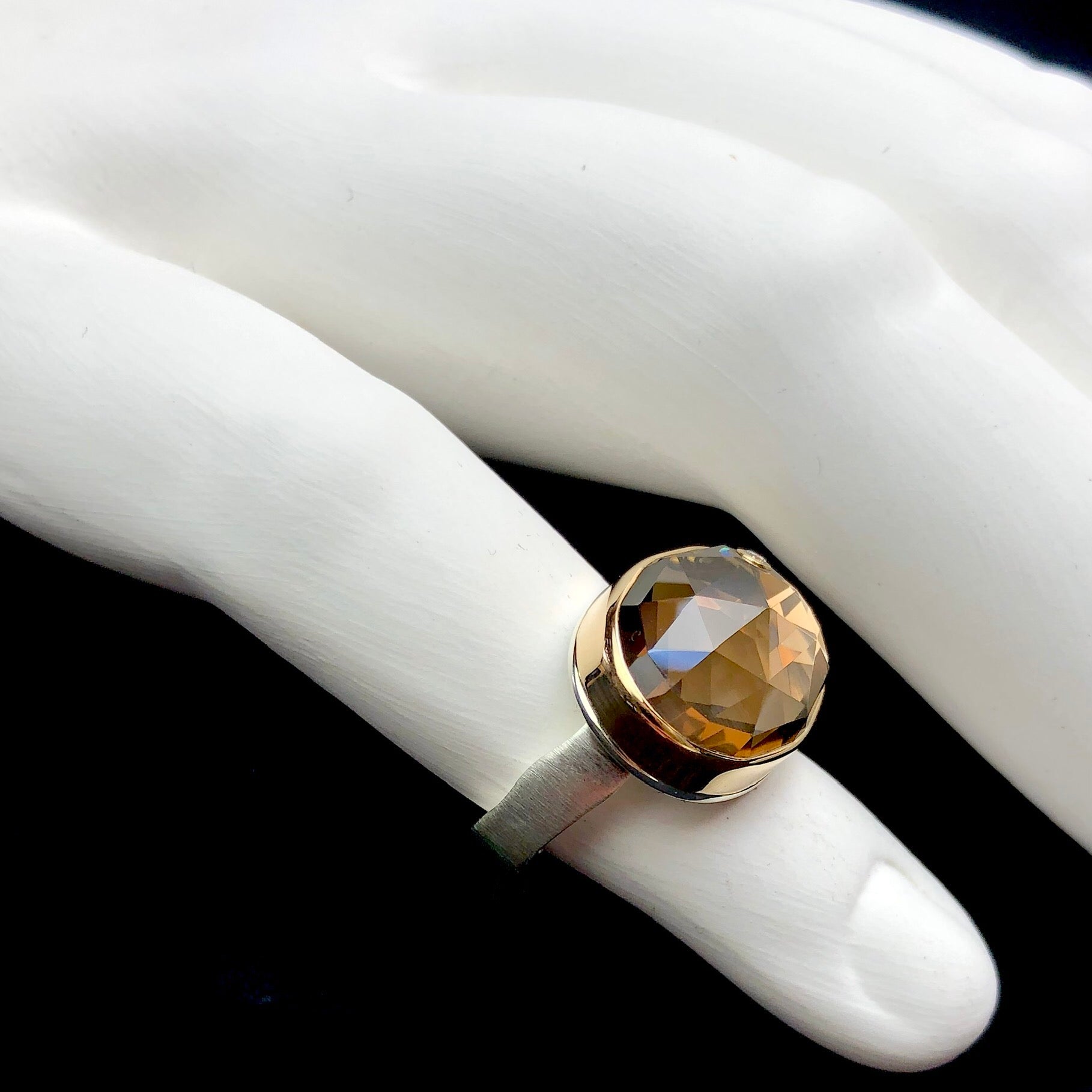 Side profile view of smokey quartz ring with comfort band on white ceramic finger