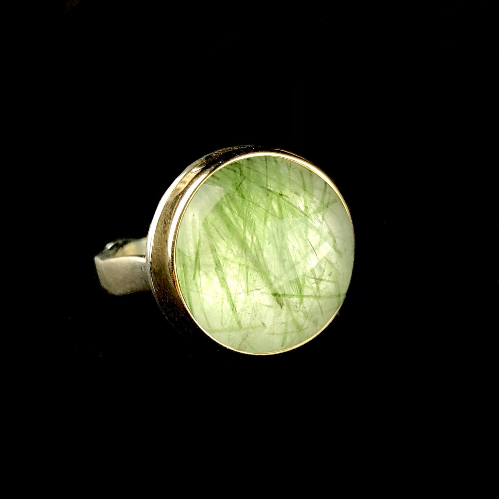 Round, light green prehnite stone with darker green traces inside ring