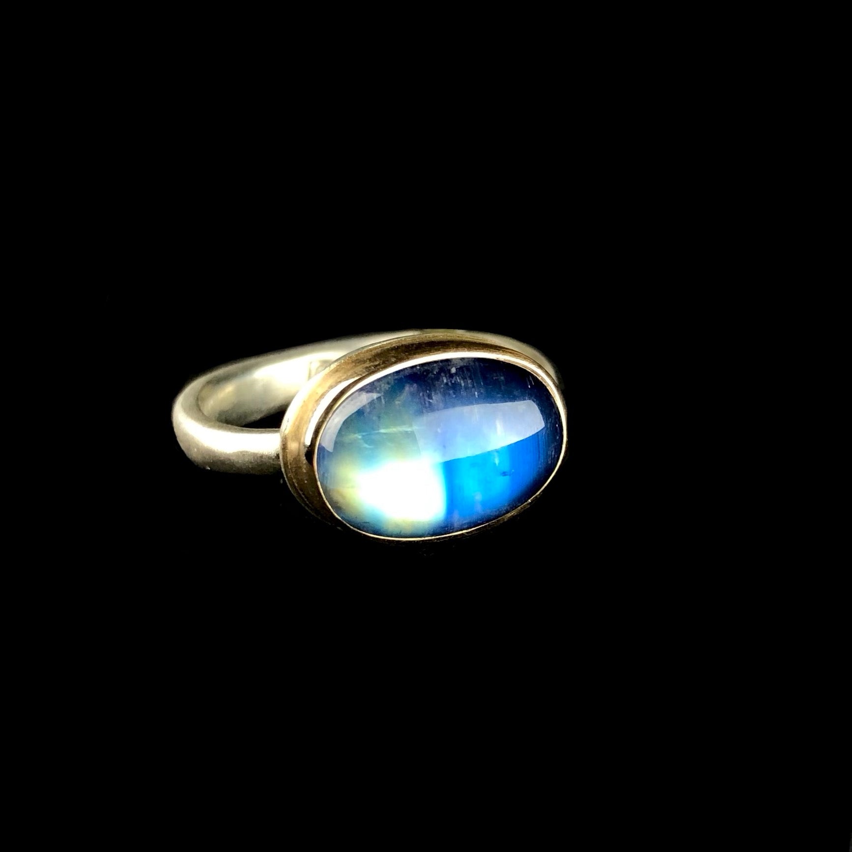 Oval shaped white and blue colored rainbow moonstone ring