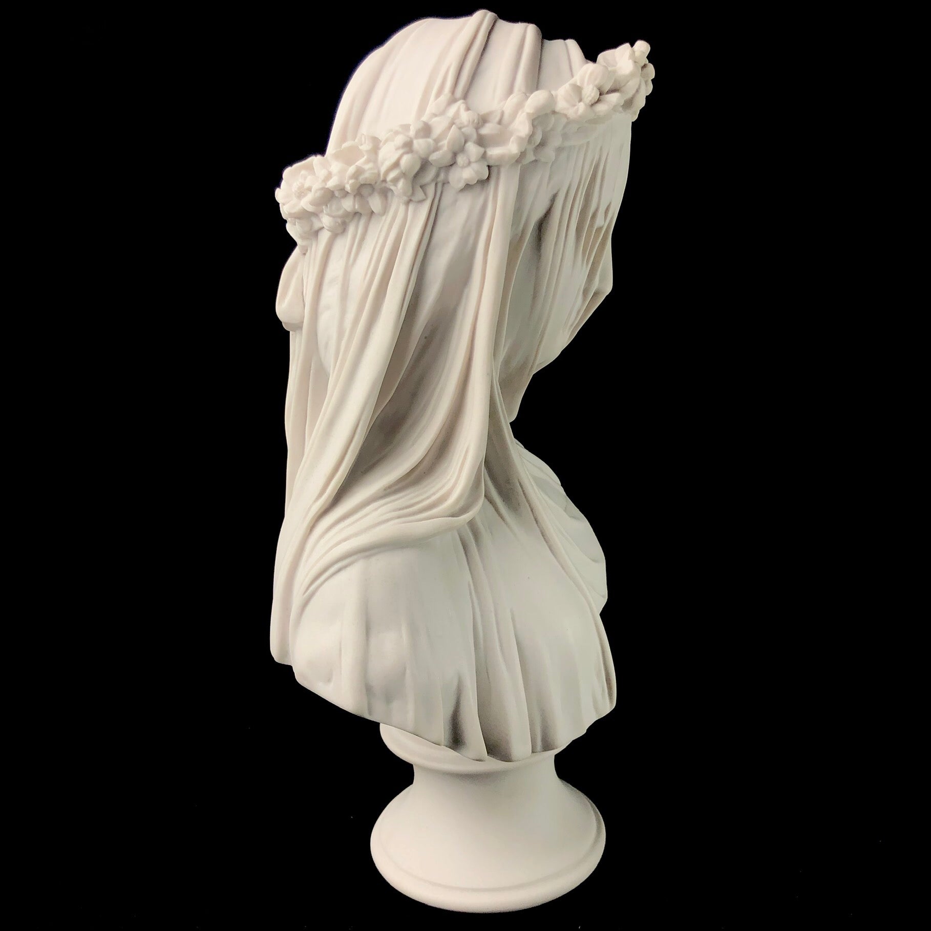 Side view of white marble vailed bride bust on pedestal