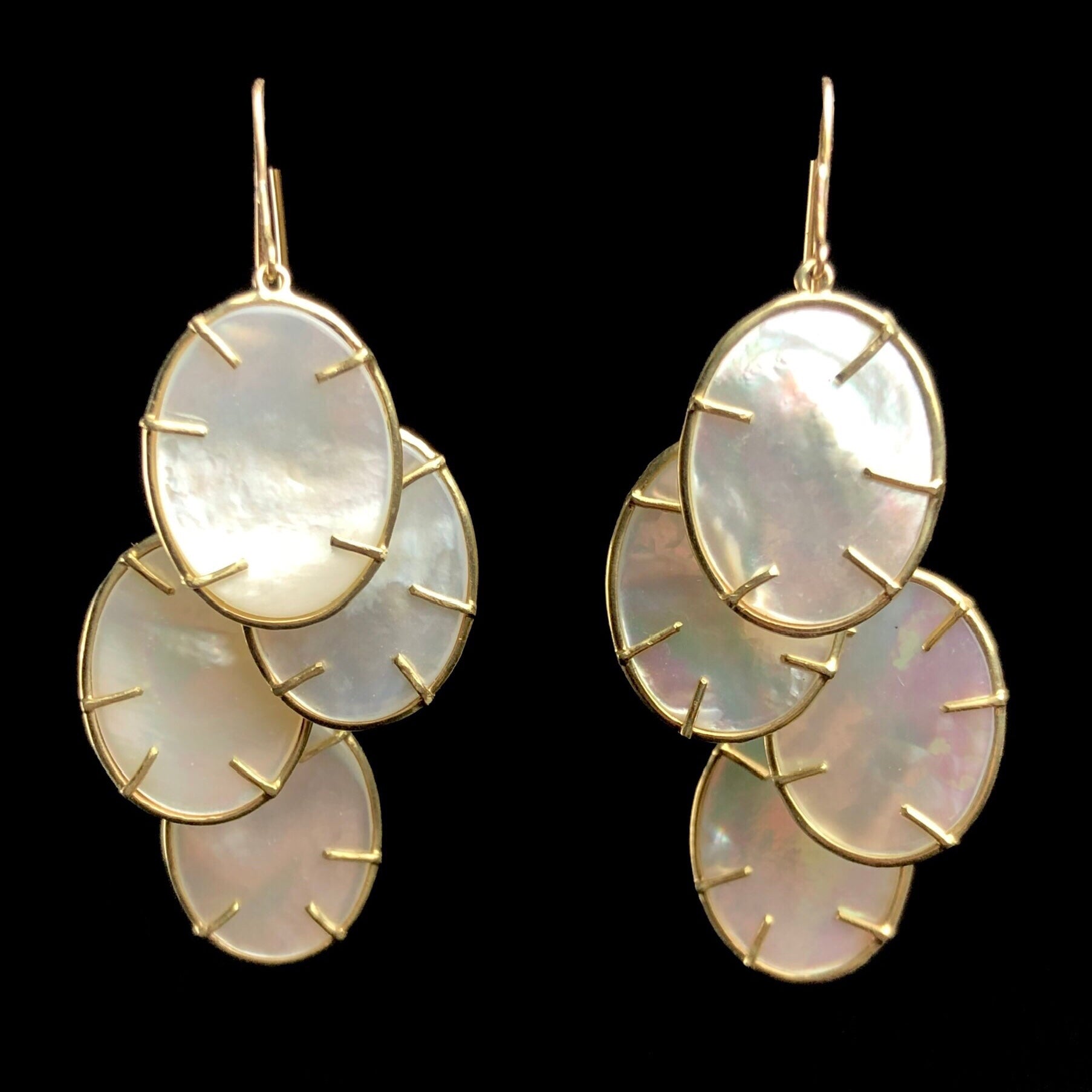 Silver Dollar Earrings hanging side by side each with four white, oval medallions held by gold prongs