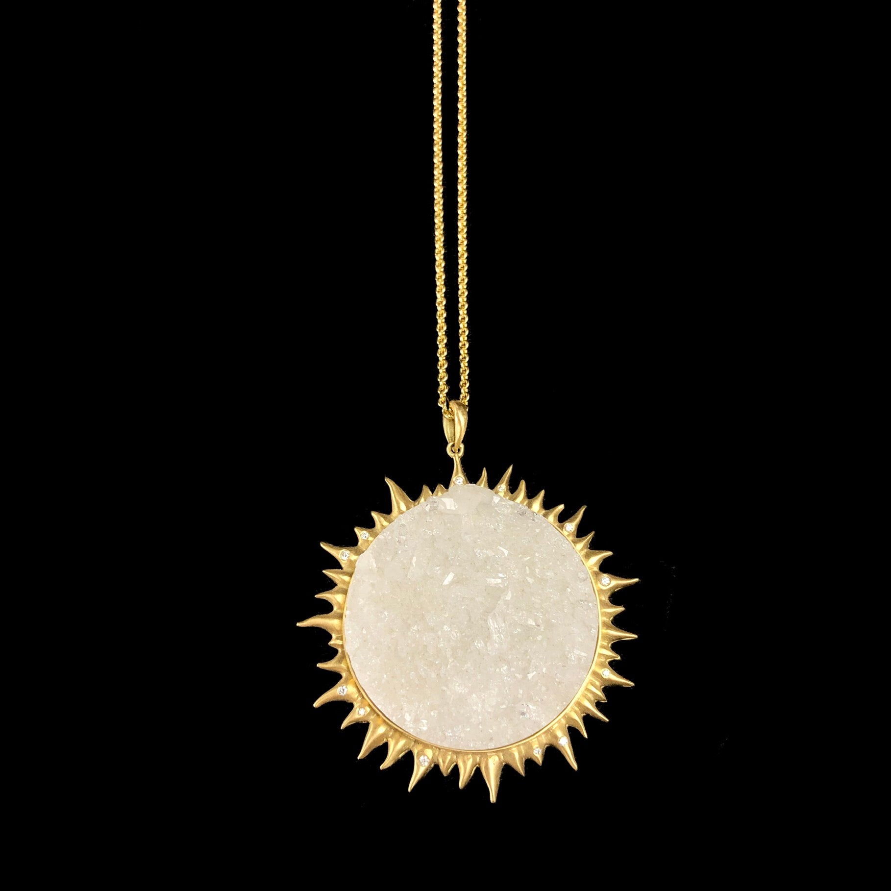 Round section of quartz crystals in gold setting resembling the rays of the sun on chain