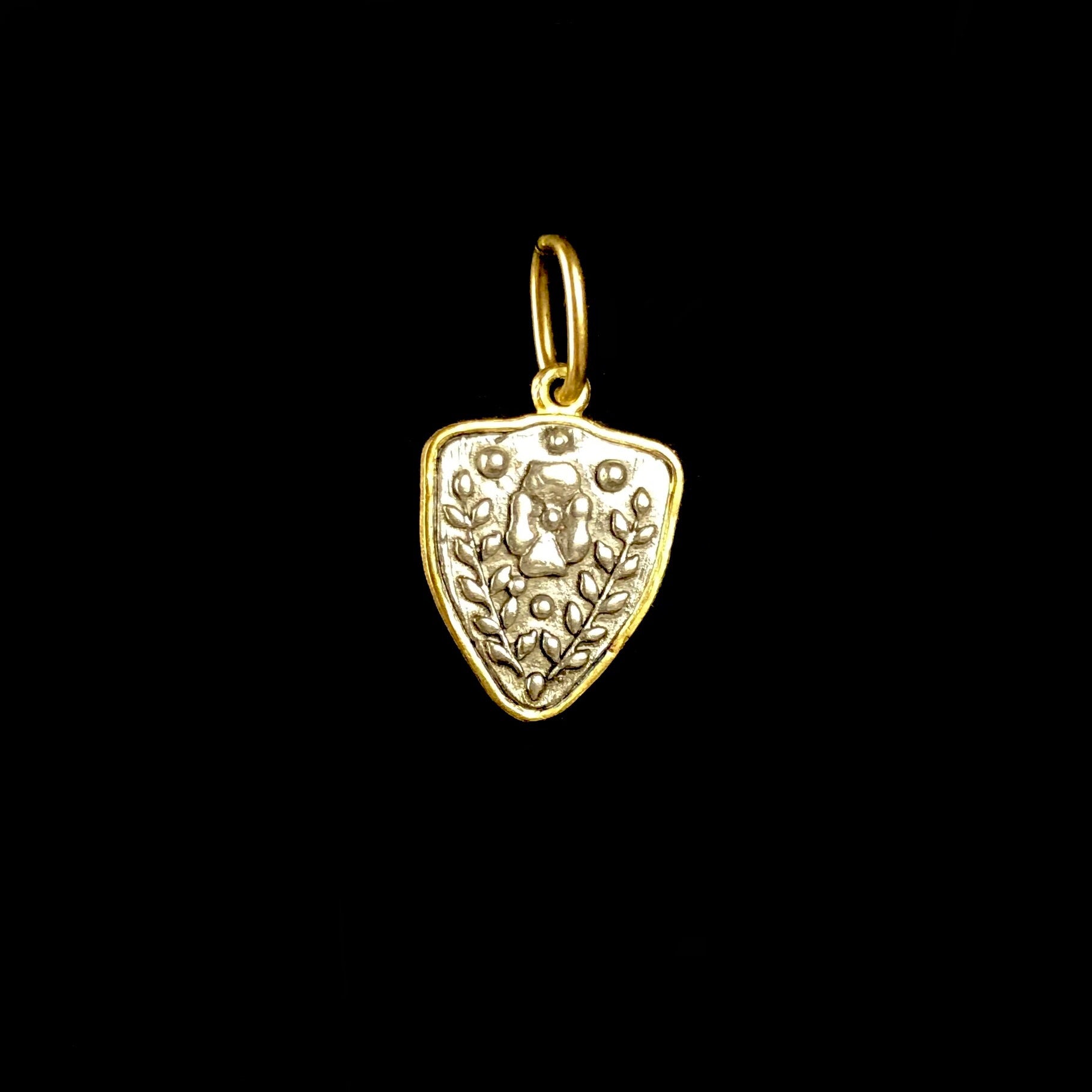 Back side of Fox and Flower Charm with relief of a flower with two branches on either side
