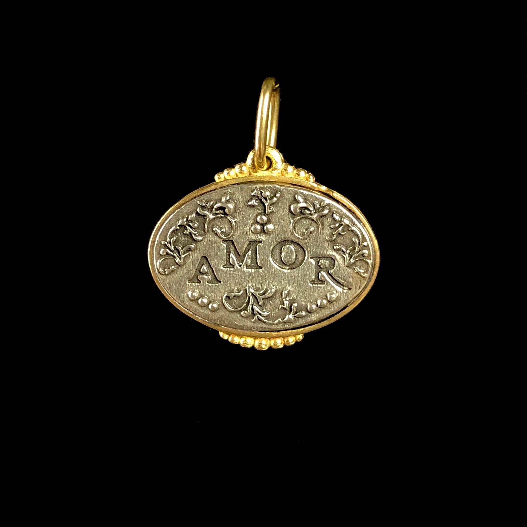 The etched word amor in silver with gold frame