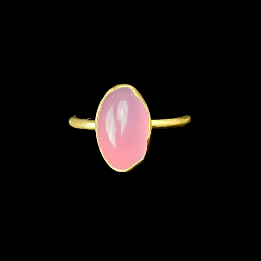Gold ring with a pink stone on a black background