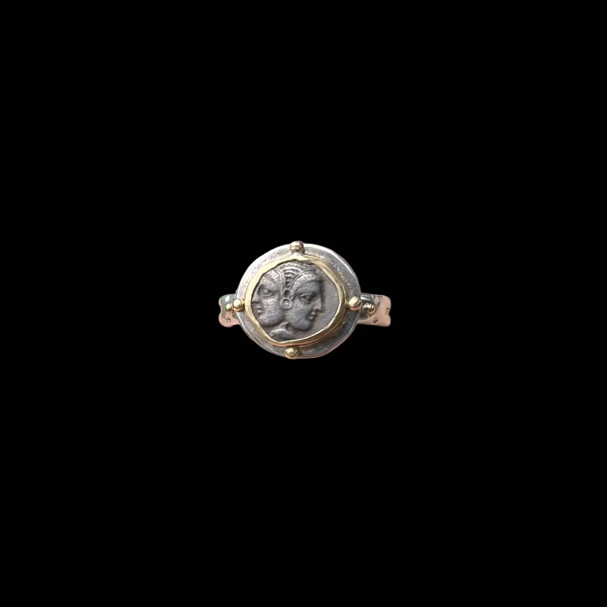 Ring with a face design against a black background