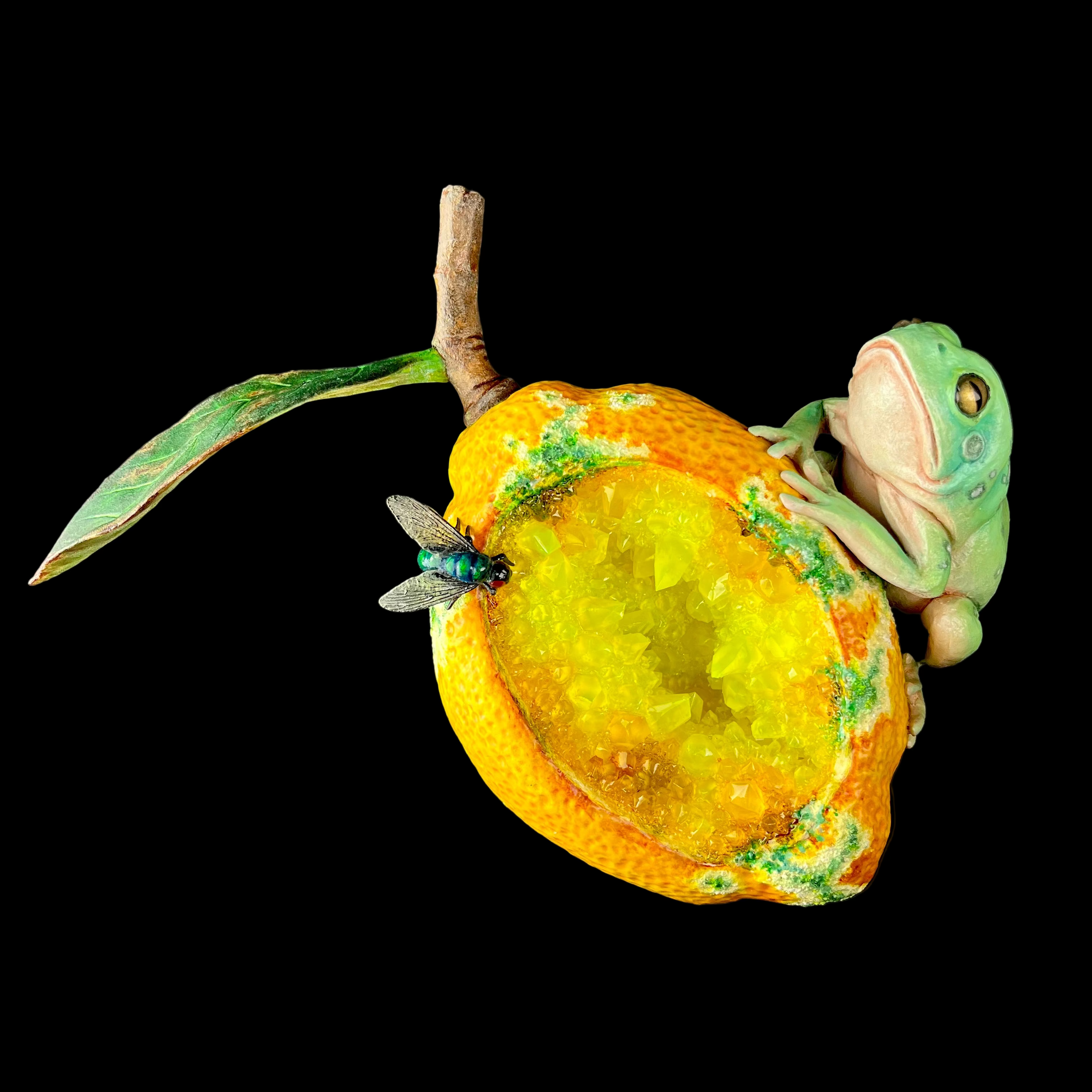 Decorative item with a frog on a geode and leaf against a dark background