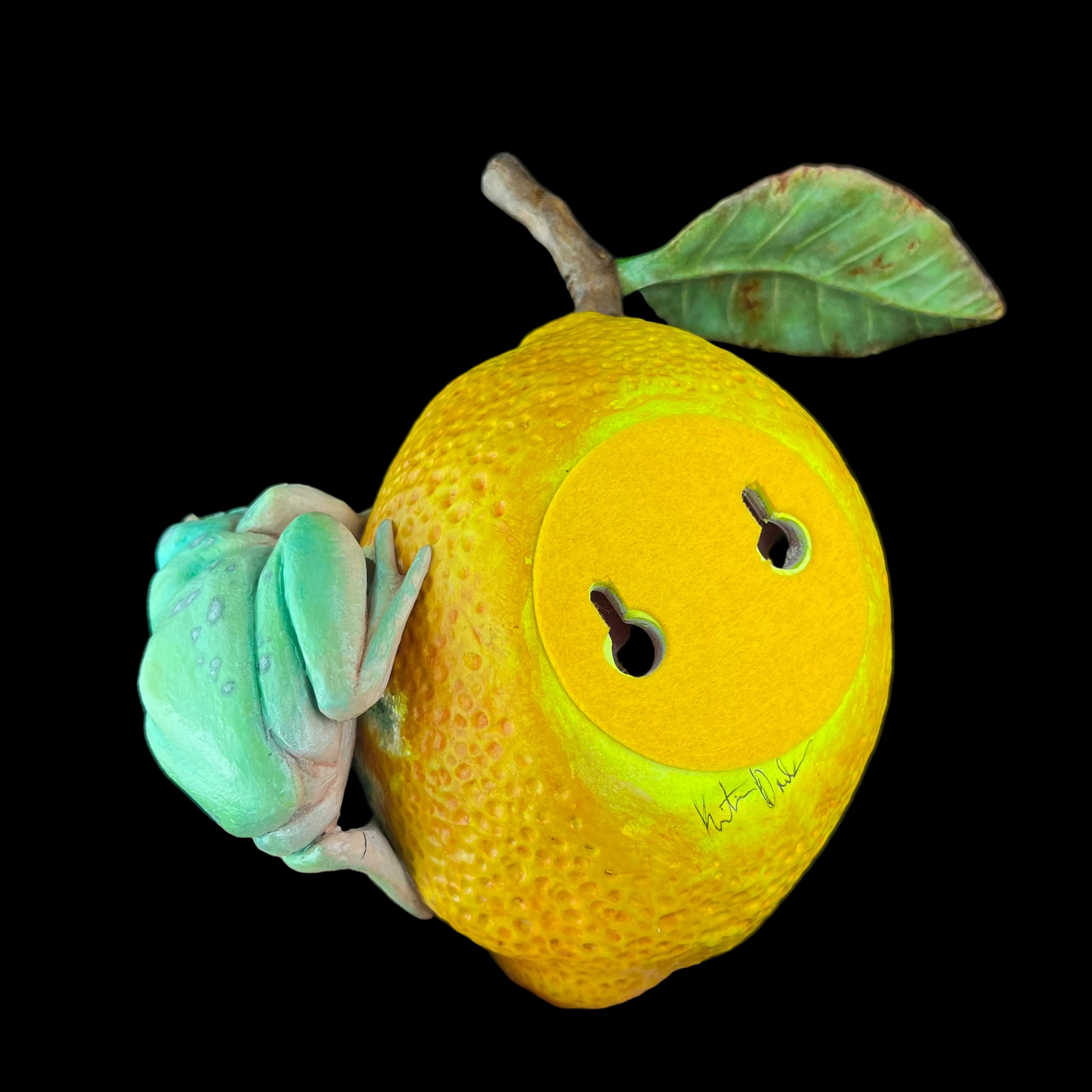 Hand holding a yellow fruit with a frog on top against a black background