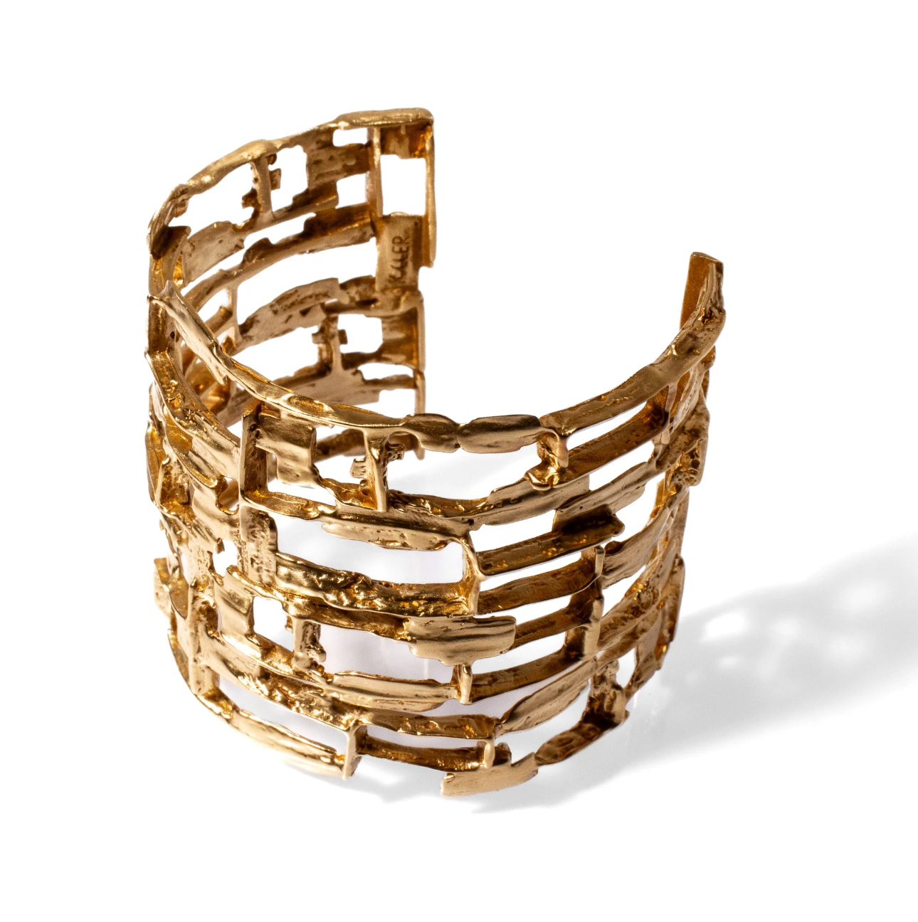 Gold cuff bracelet on a white background