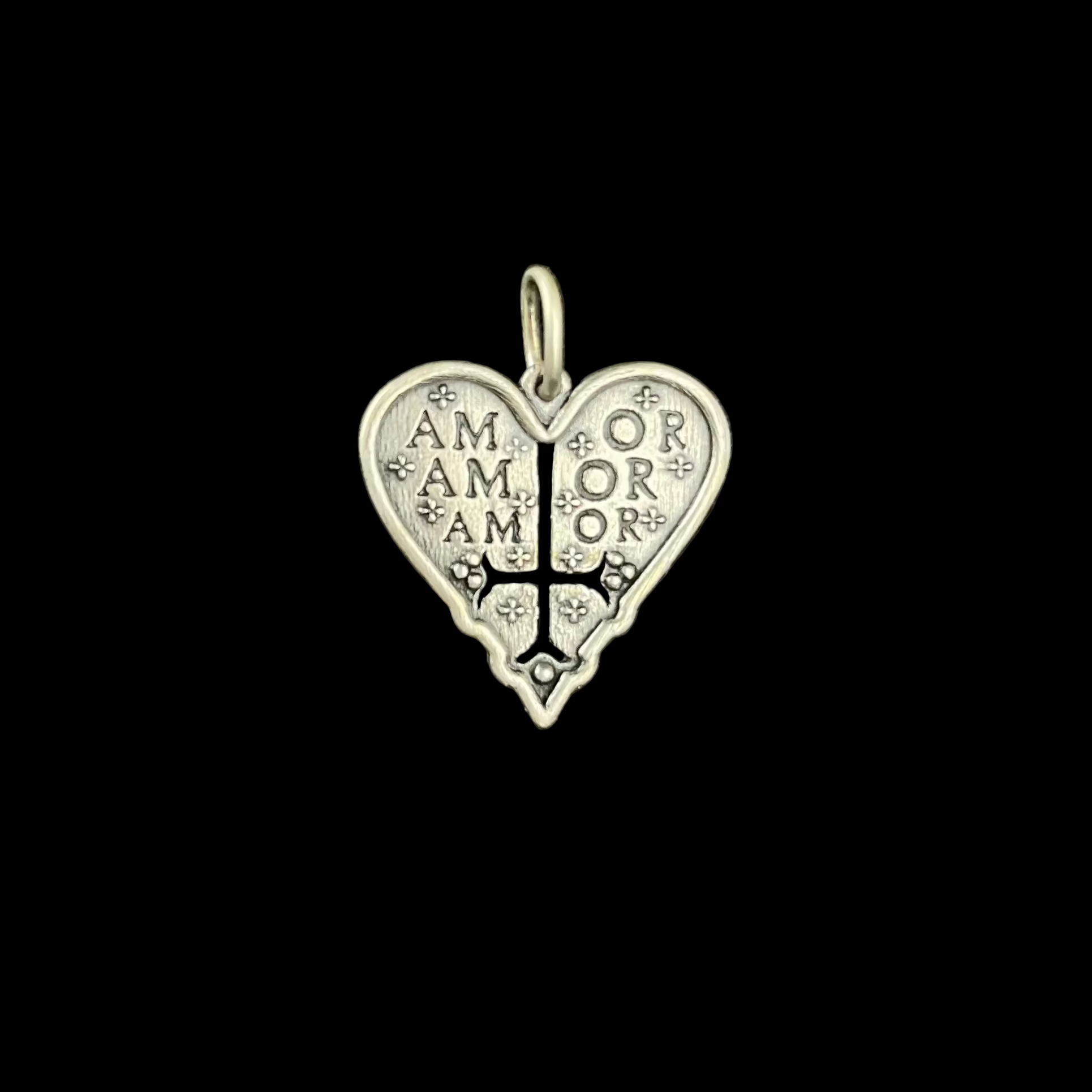 Silver heart-shaped pendant with 'AMOR' engraving on a black background