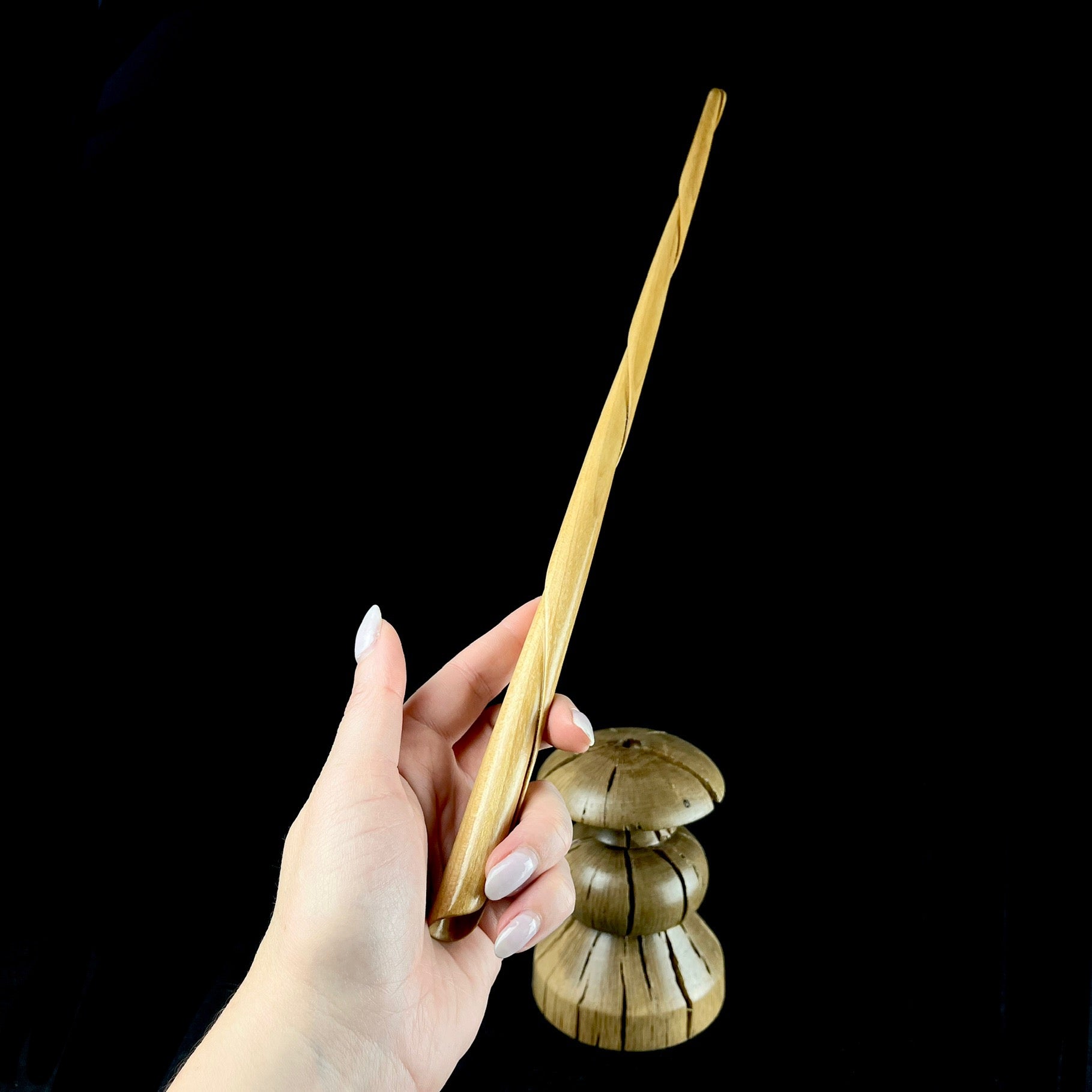 Turned Wood Wand shown in hand with base in background