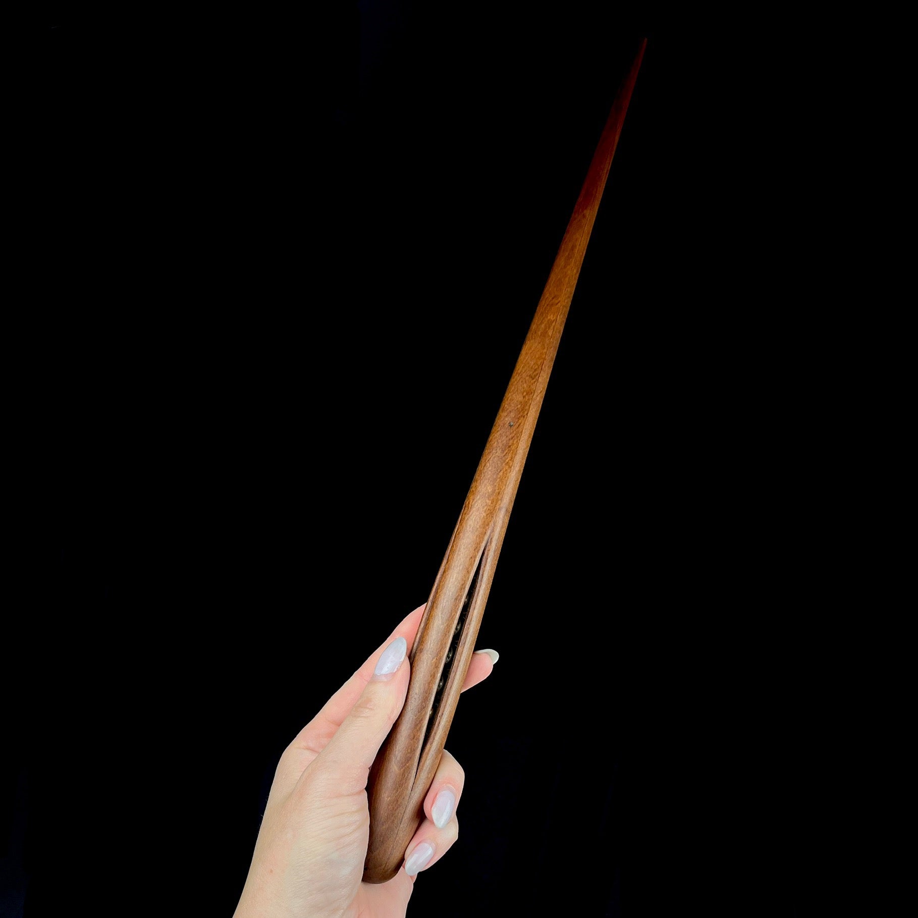 Dark wand with silver accents shown in hand