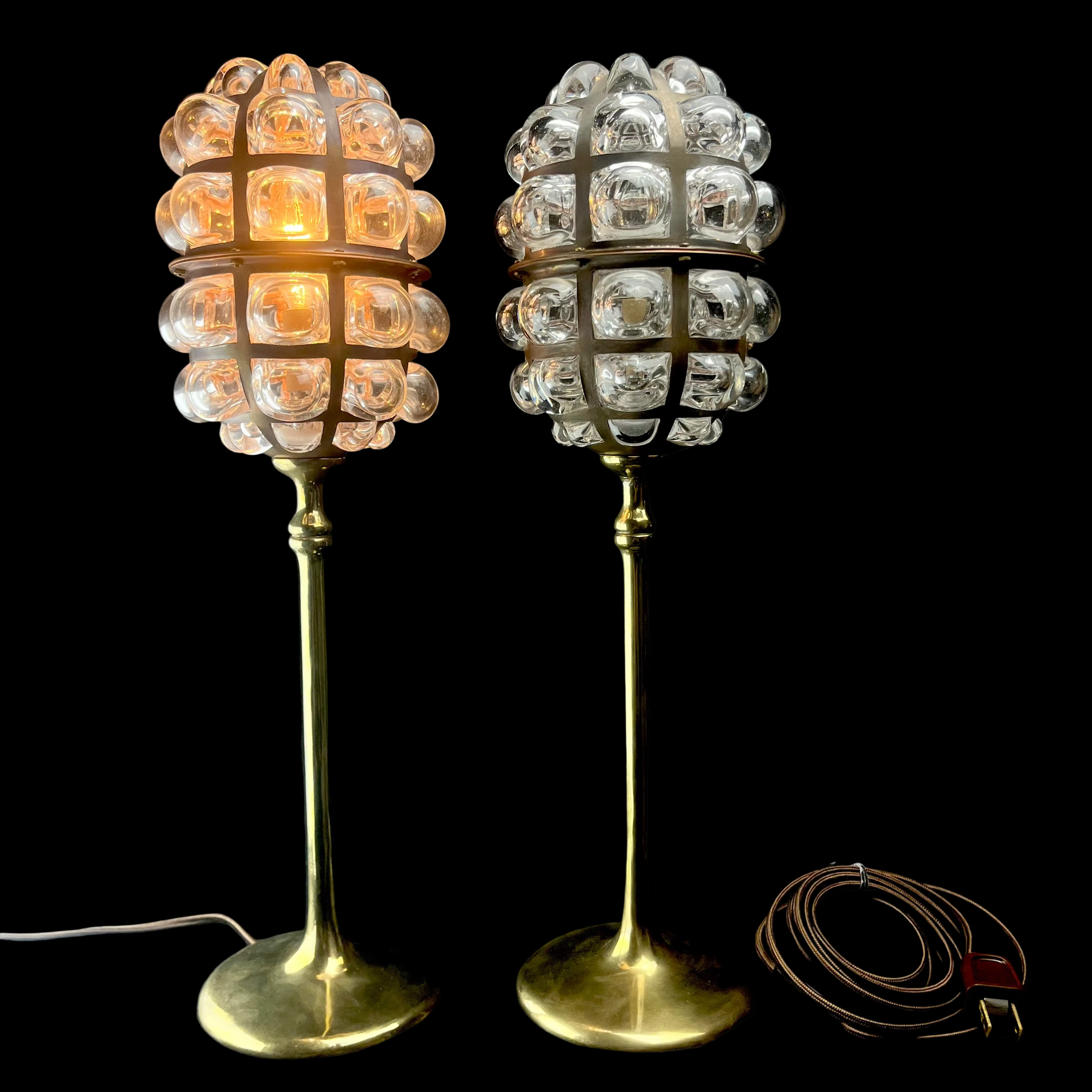 Two decorative table lamps with glass globe shades on a dark surface.