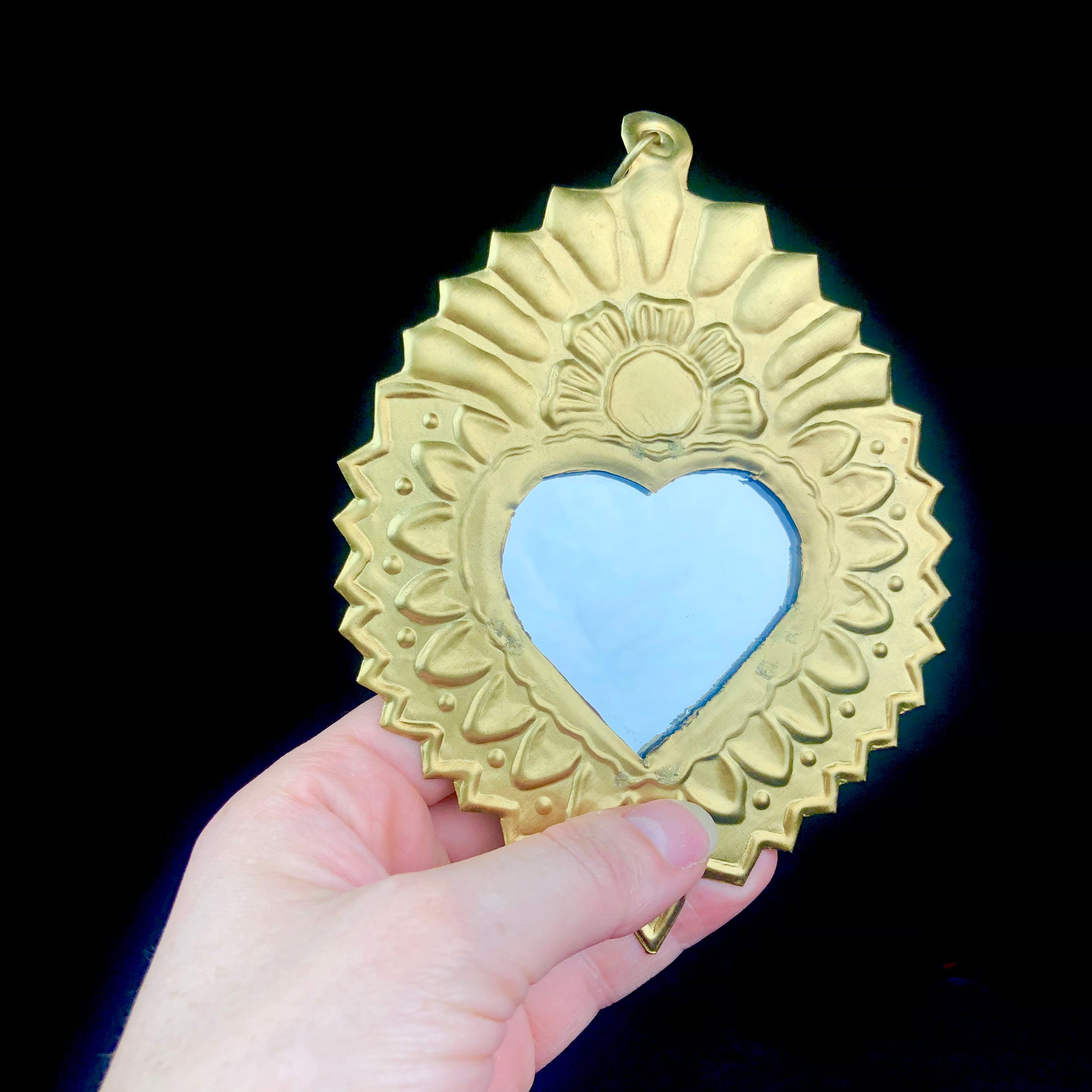 Hammered floral pattern surrounding a heart shaped mirror