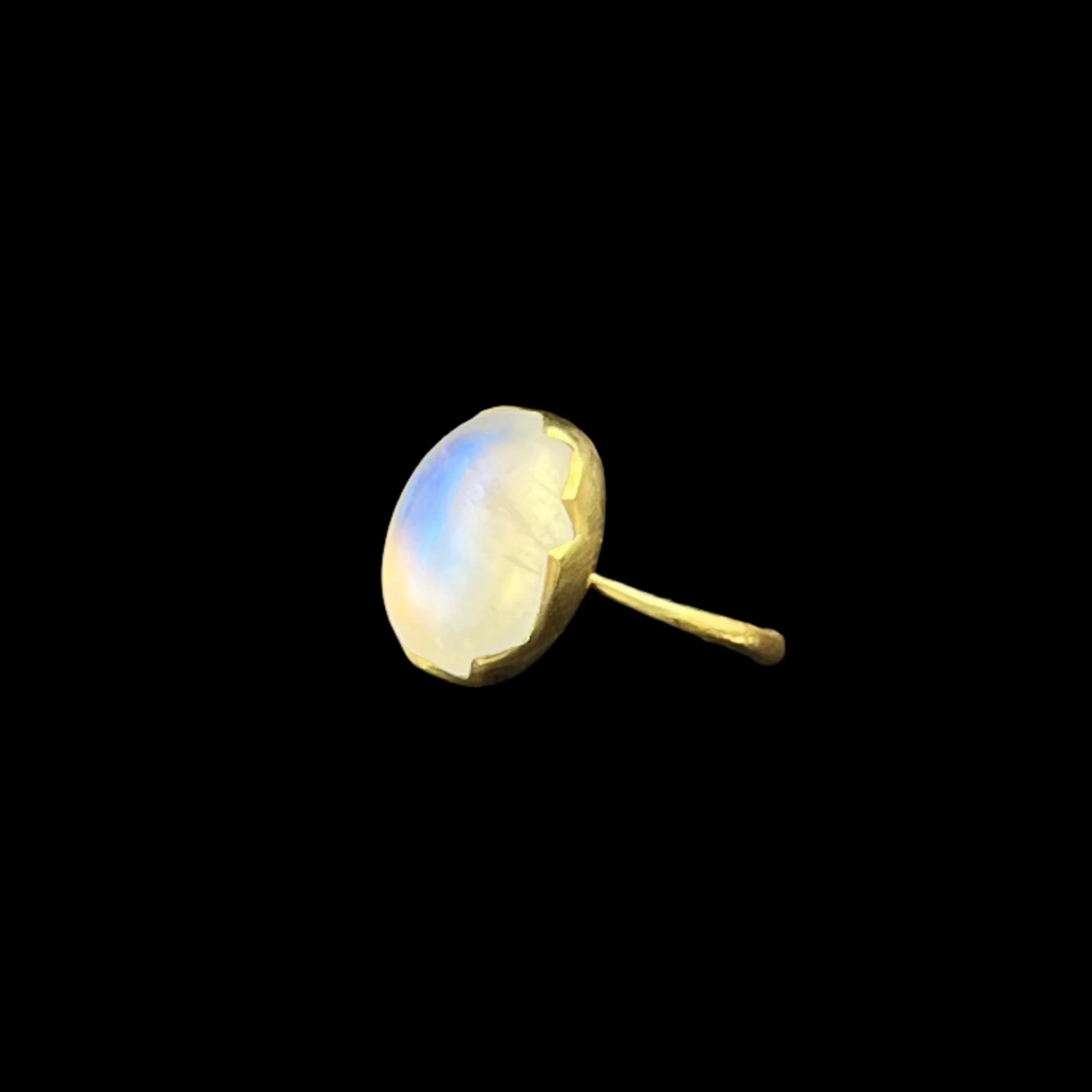 Opal ring on a black jewelry display with a dark background