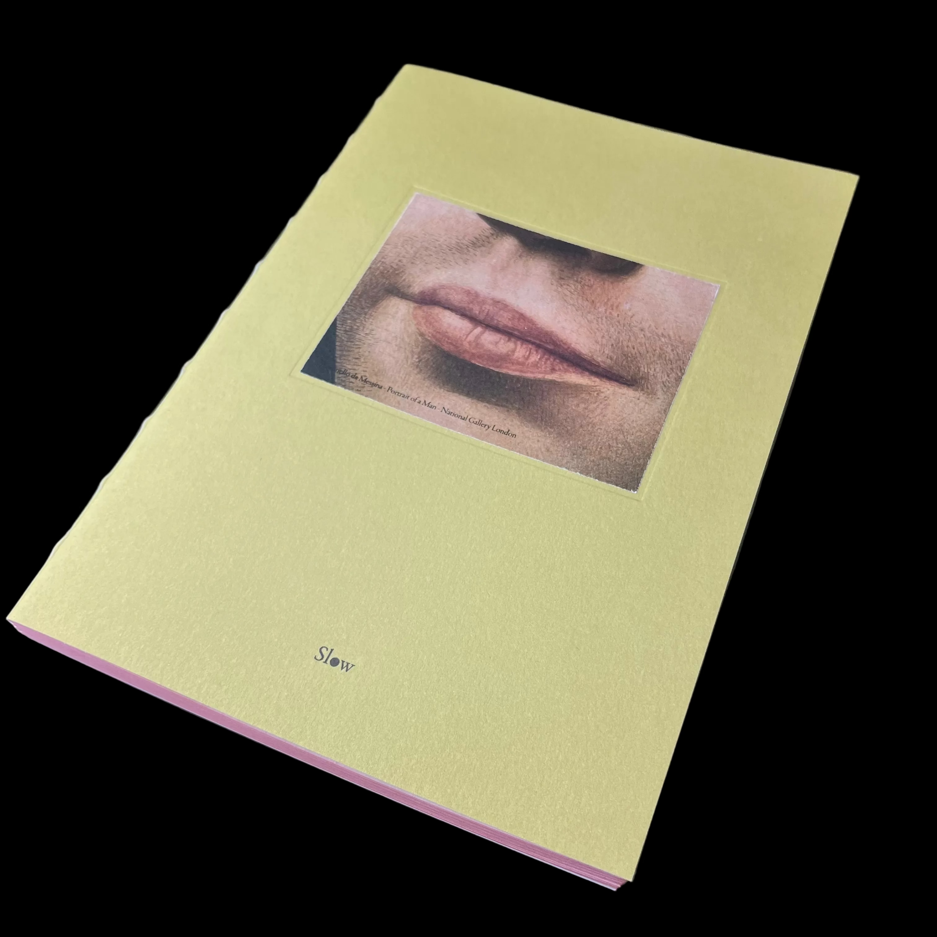 Yellow book with a photograph of a person's face on a dark surface