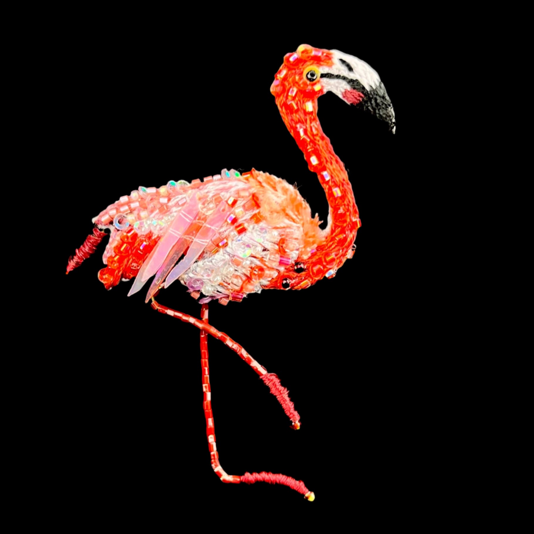 Saturated pink embroidered flamingo with sparkling sequin wings and glass bead accents standing on one foot
