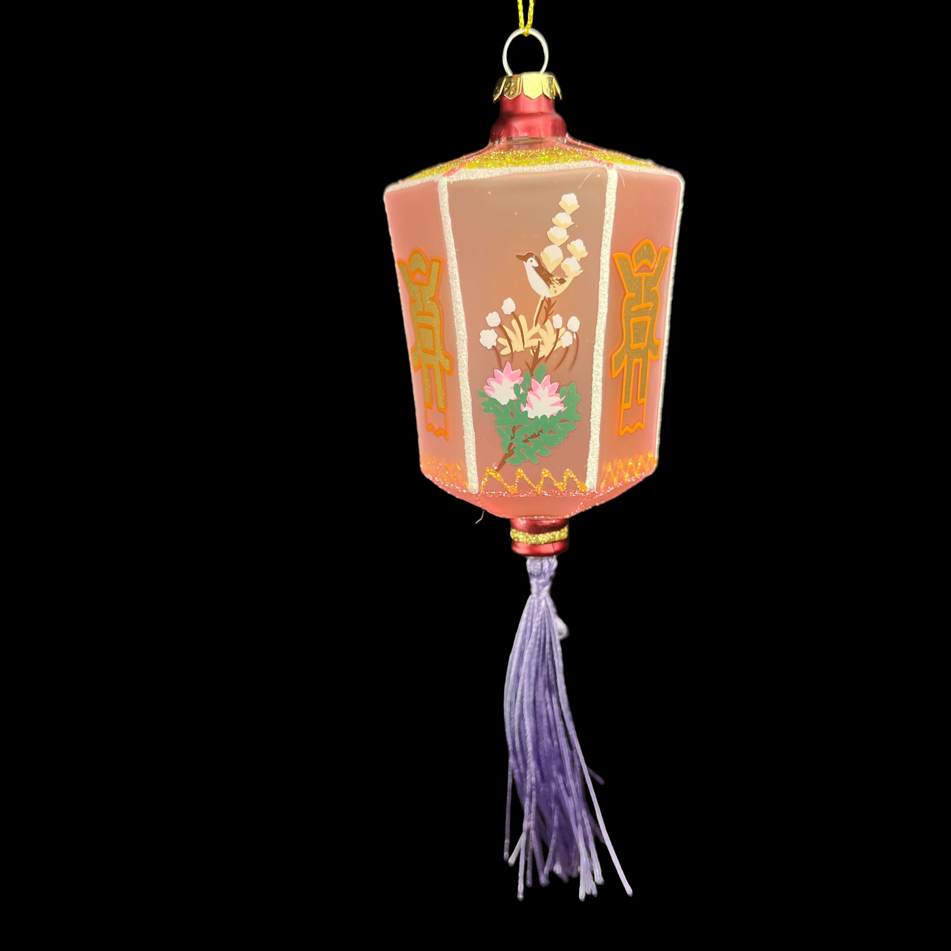 Decorative lantern ornament with floral designs on a black background