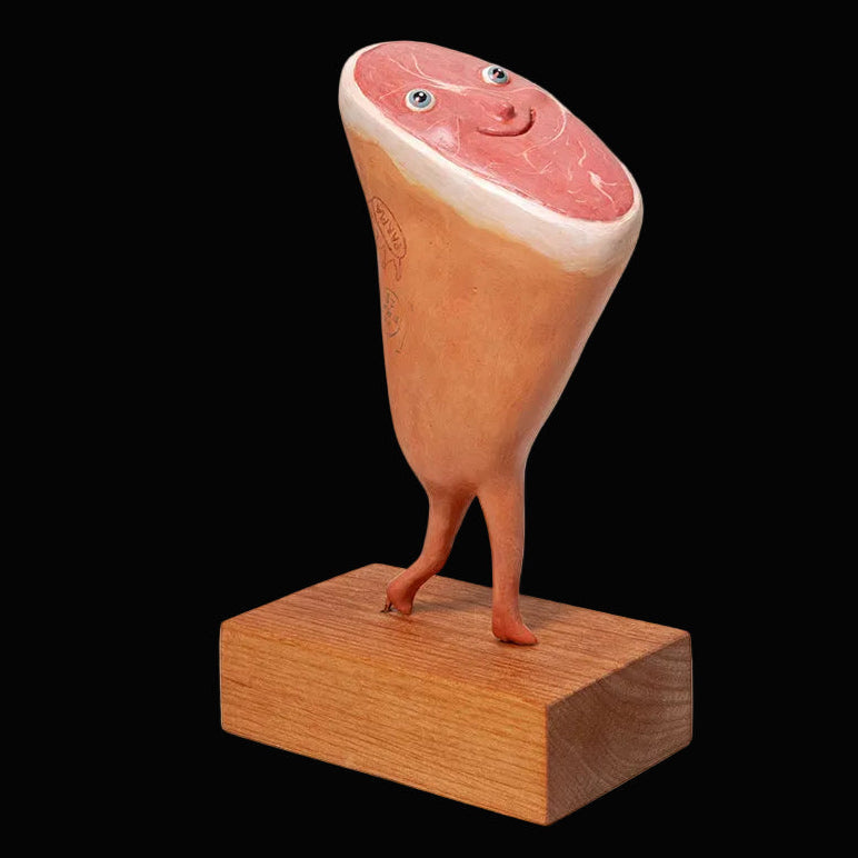 life like sculpture of prosciutto with eyes and feet on wooden block