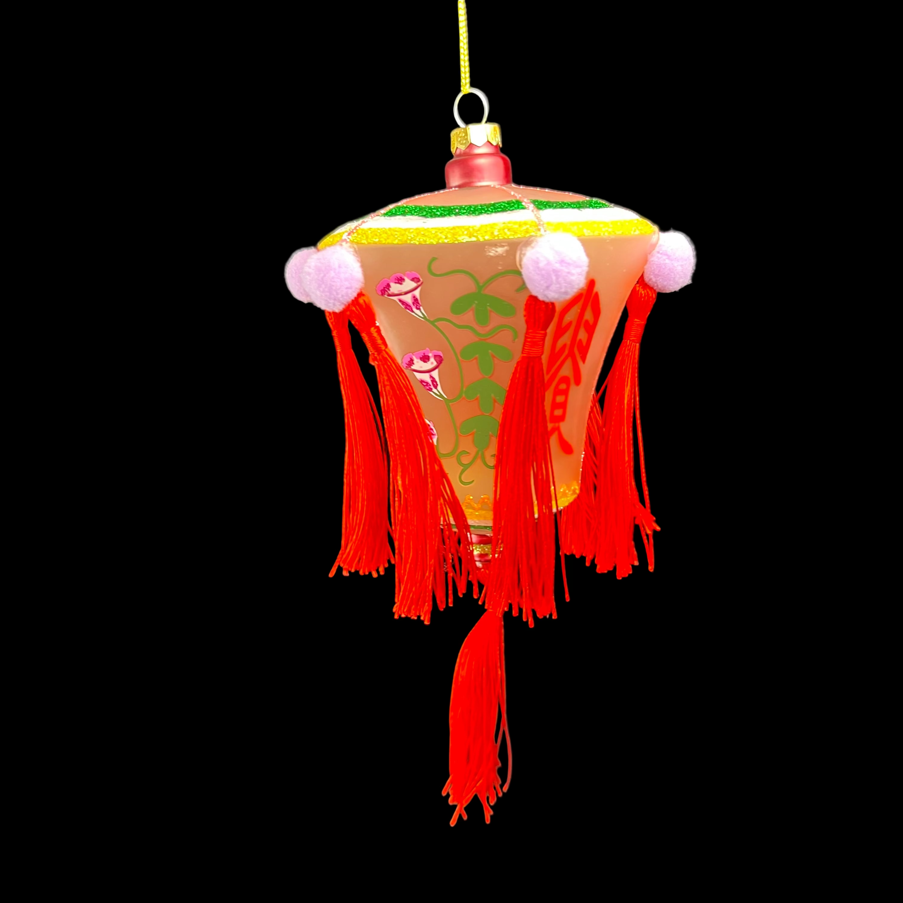 Decorative lantern with red tassels and floral patterns on a dark background