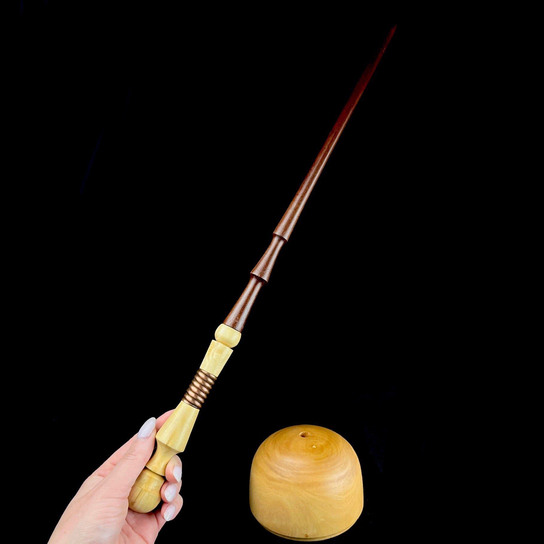 Wood Wand shown in hand with rounded base beside
