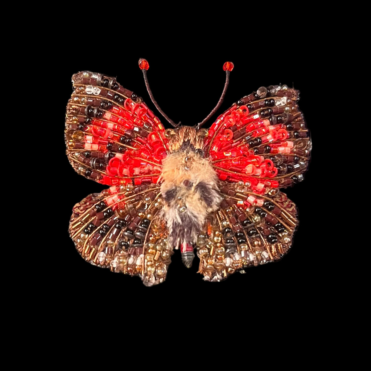 Embroidered butterfly shape with brown and read glass beads that create lifelike realism