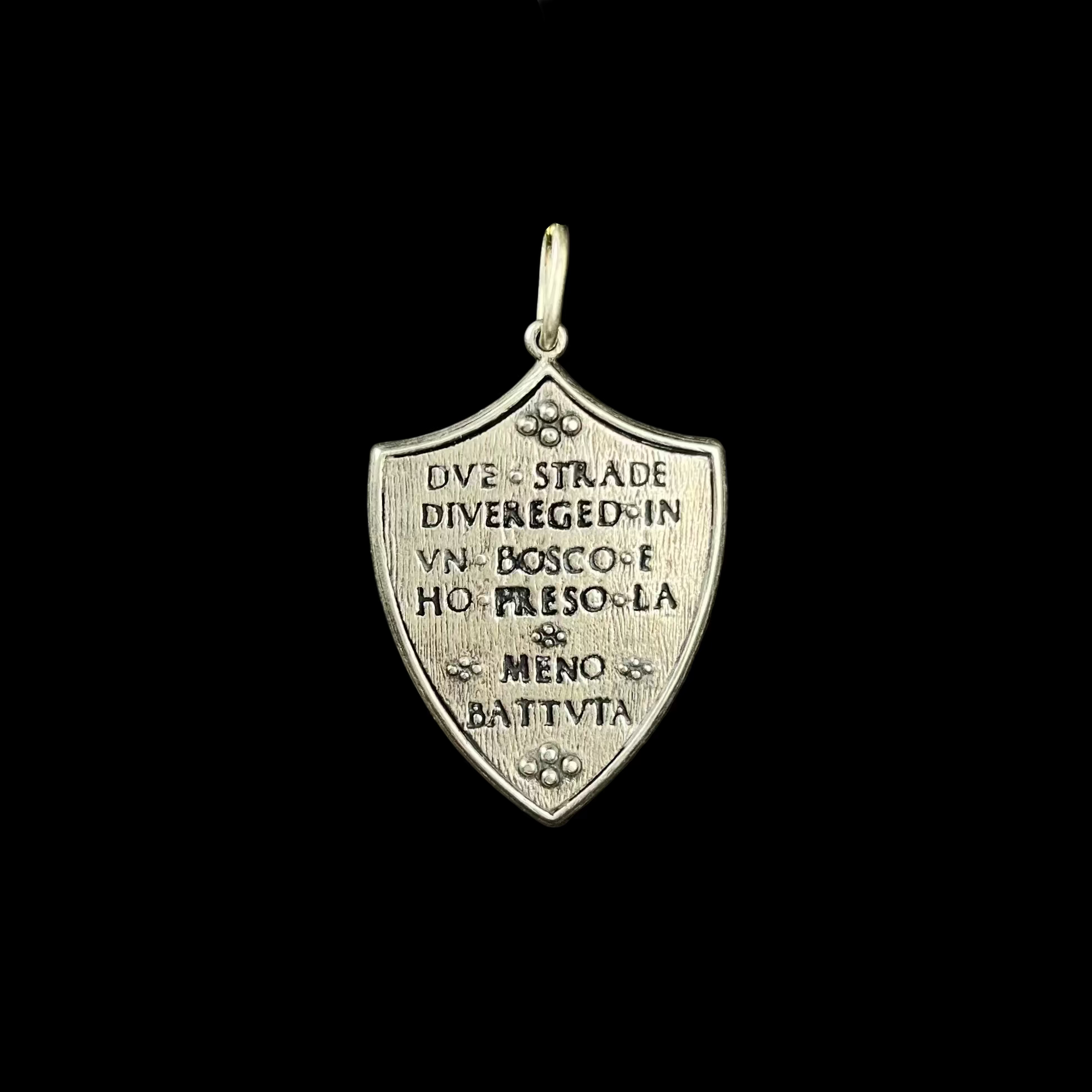 Silver pendant with engraved text on a black background