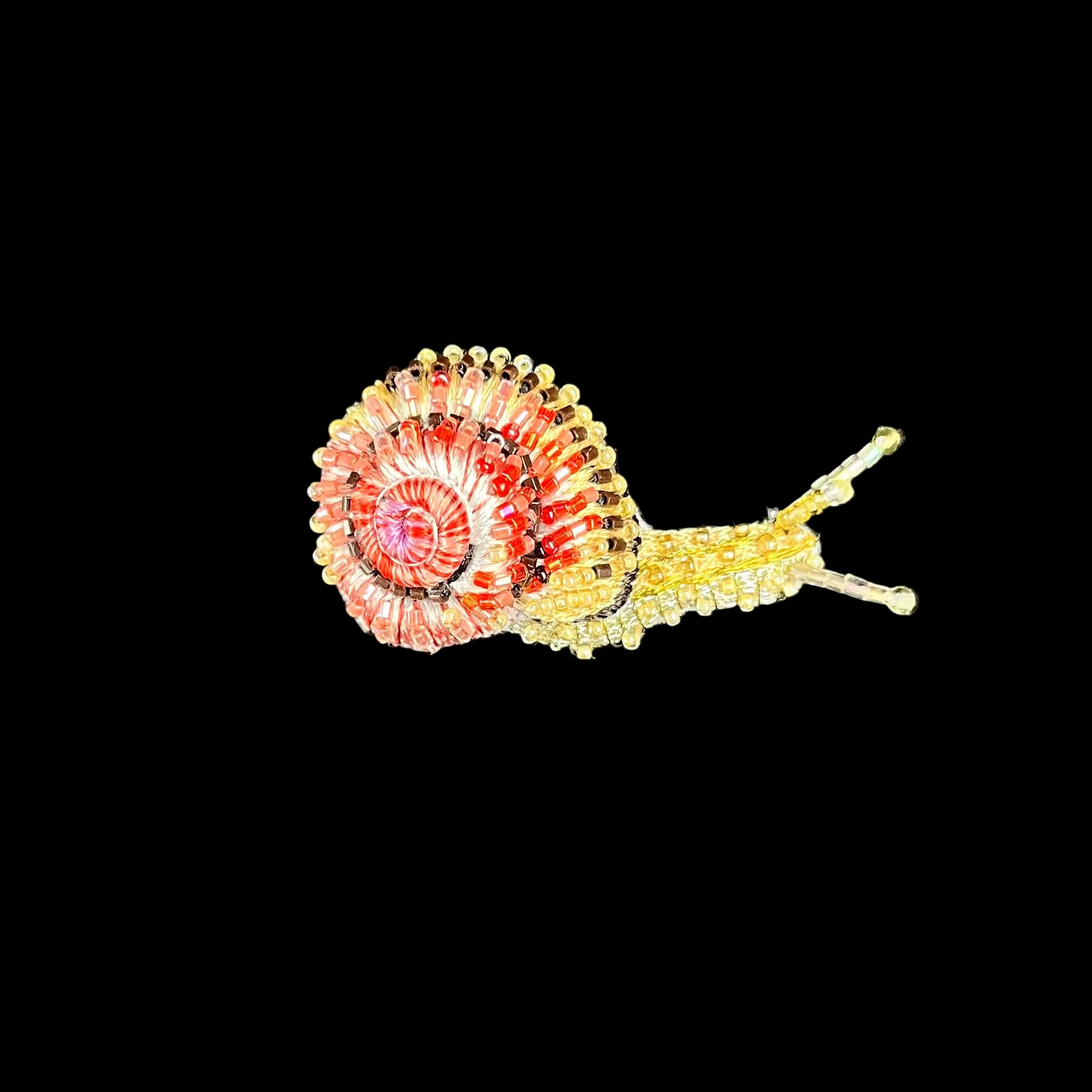 Decorative snail on a black square base with a black background