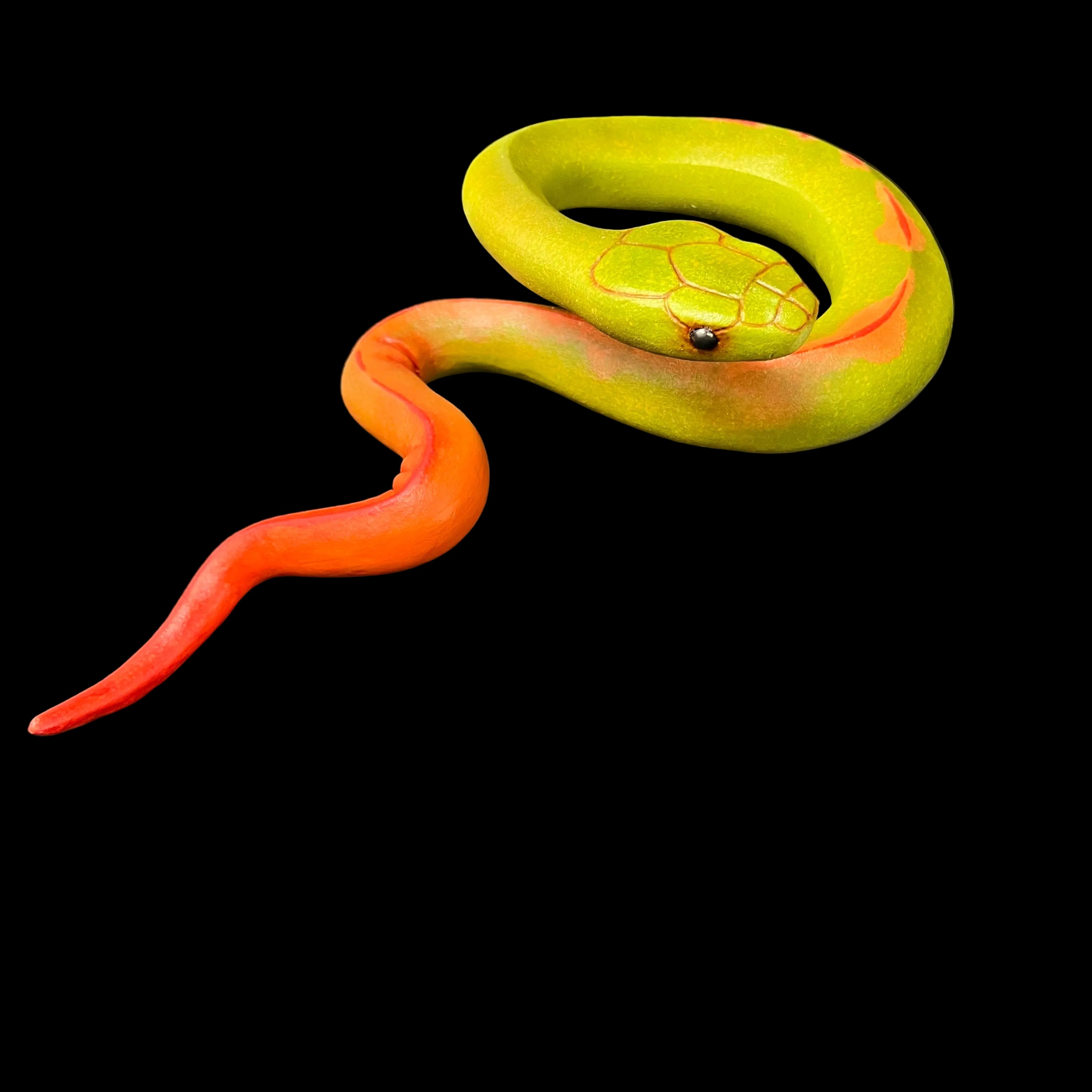 Model of a green and orange snake on a black background