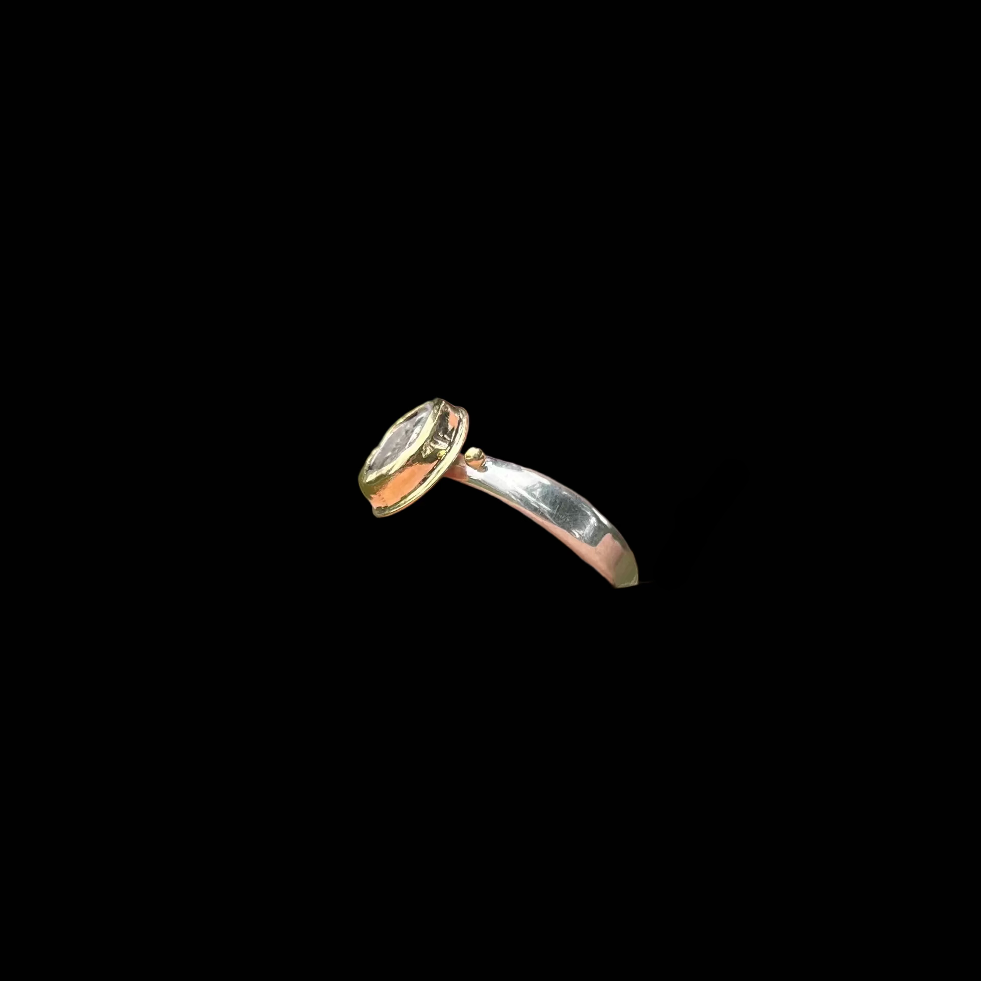 Side view of silver ring on black background